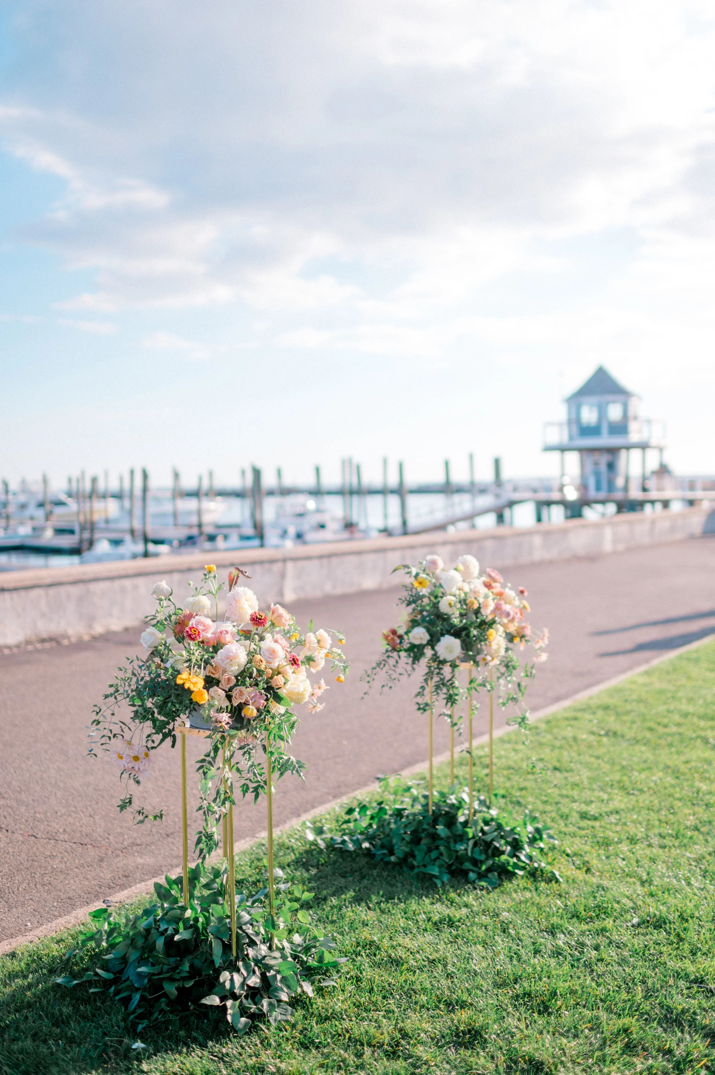 Gold stand floral installations with peach and orange zinnias