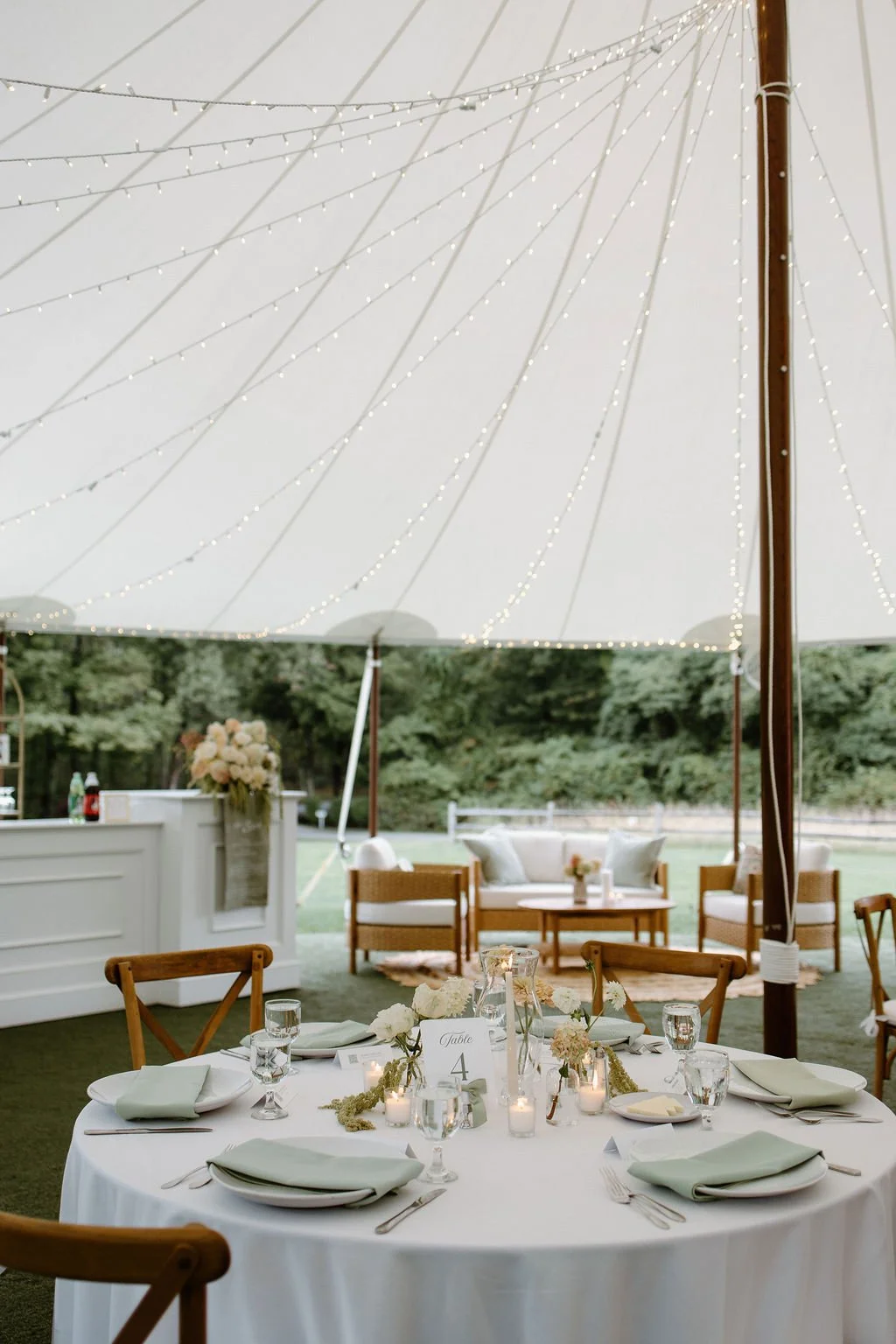 Garden farm wedding table centerpiece with mixed bud vases, seasonal garden flowers, spray and cottage roses, and glowing votive candles styled for an elegant reception at Smith Farm Gardens.