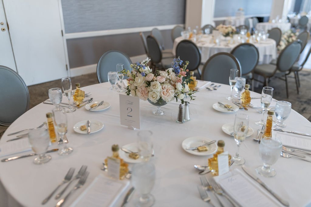Petite floral arrangement in a small ceramic bowl on a cocktail hour patio table at Water's Edge Resort and Spa Connecticut, designed by First Blush Floral Design