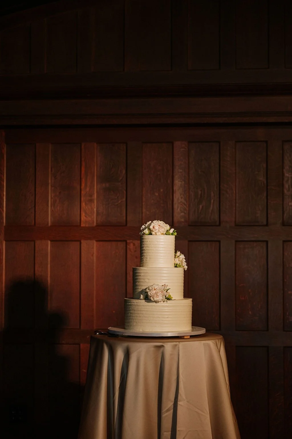 White wedding cake decorated with soft neutral flowers