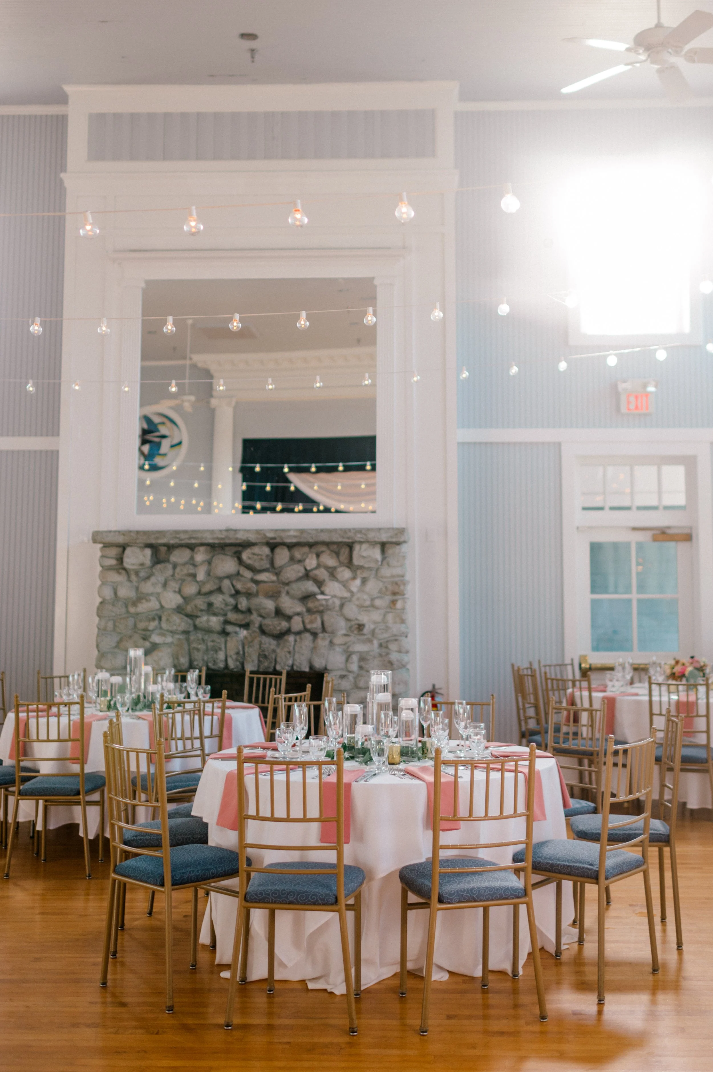 Bistro string lights illuminating romantic coastal reception