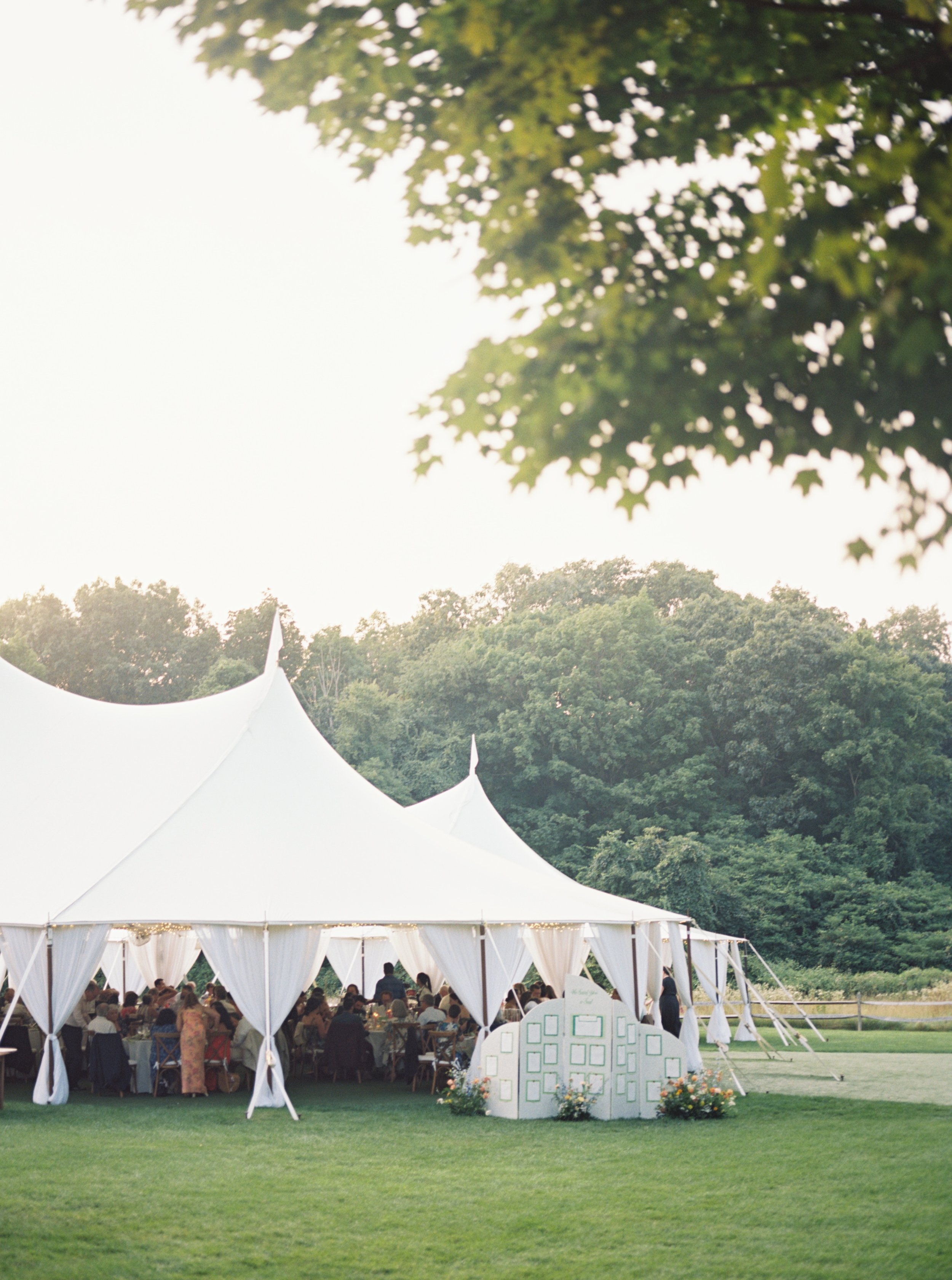 Bride and groom posed near the historic white farmhouse at Smith Farm Gardens, highlighting the timeless charm of a New England garden wedding venue.