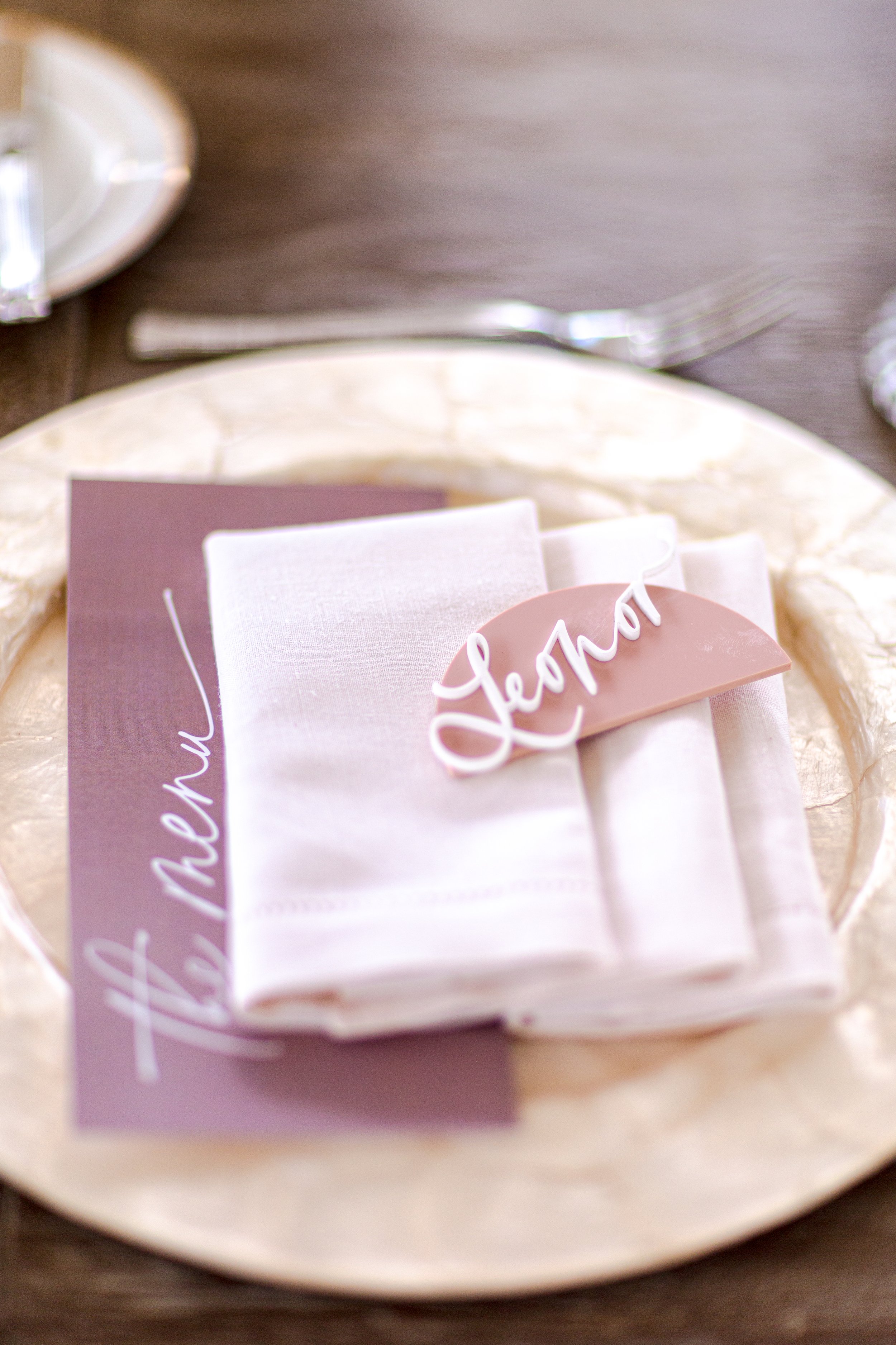 Stone charger and folded linen napkin in a lavender baby shower tablescape