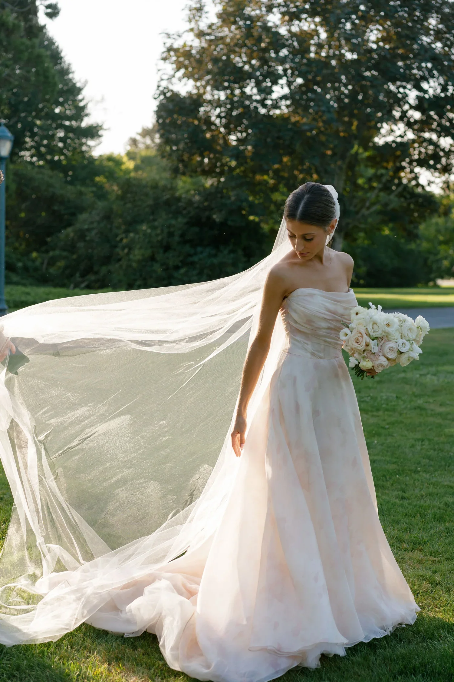 Bride with cathedral veil photographed against the historic stone architecture of Eolia Mansion.
