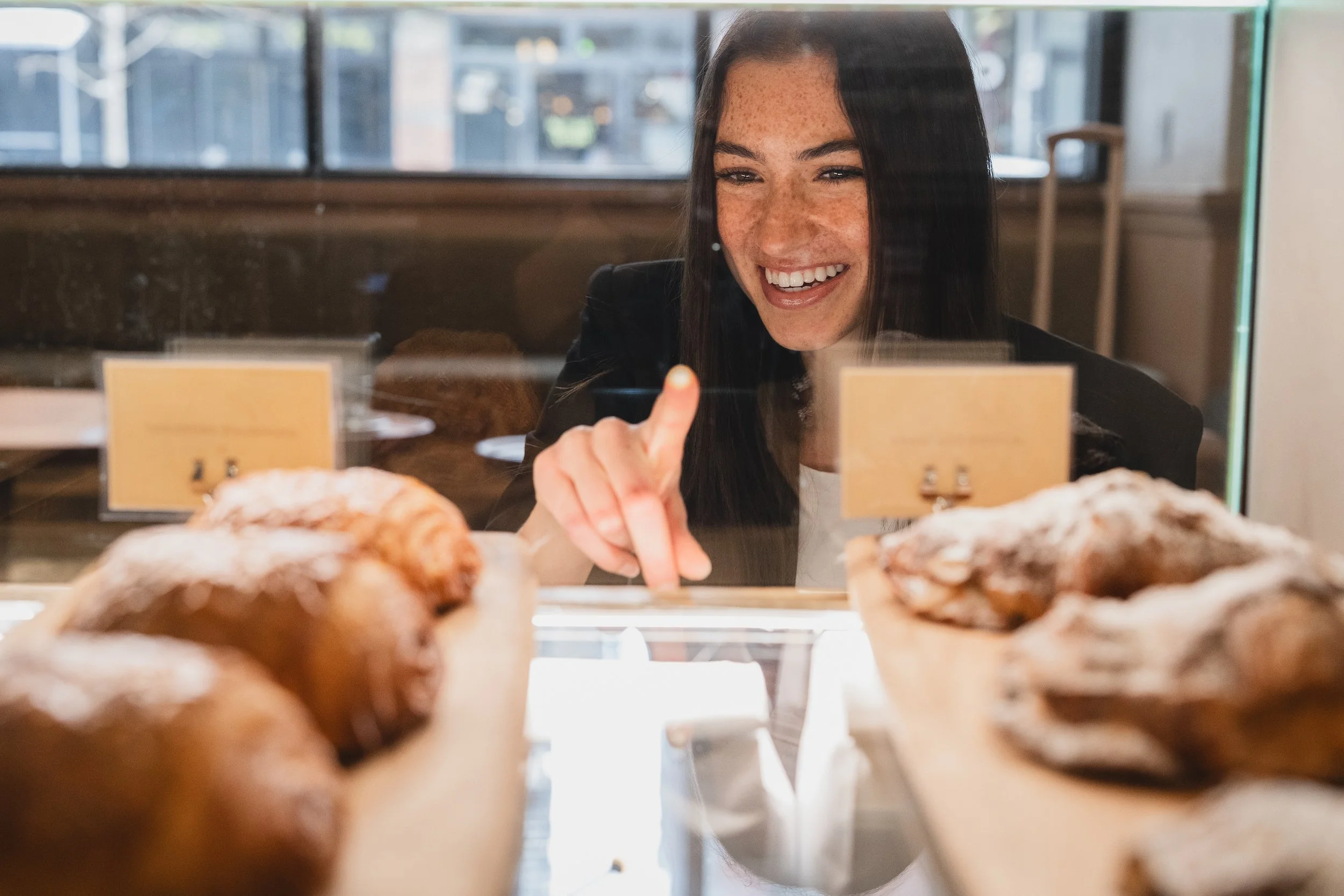 happy hole in the wall customer choosing a pastry to go with her hole in the wall coffee in the lower east side