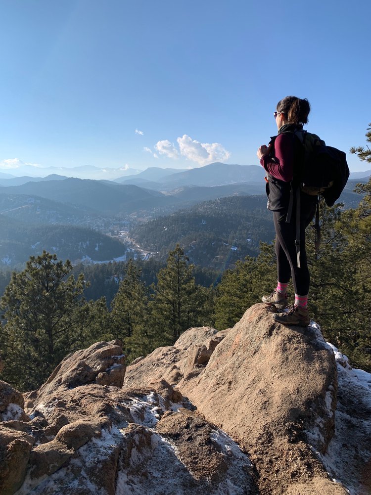 Woman Stands on Summit of Mountain in Colorado