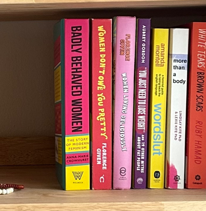 Bookshelf with colorful feminist therapy books.