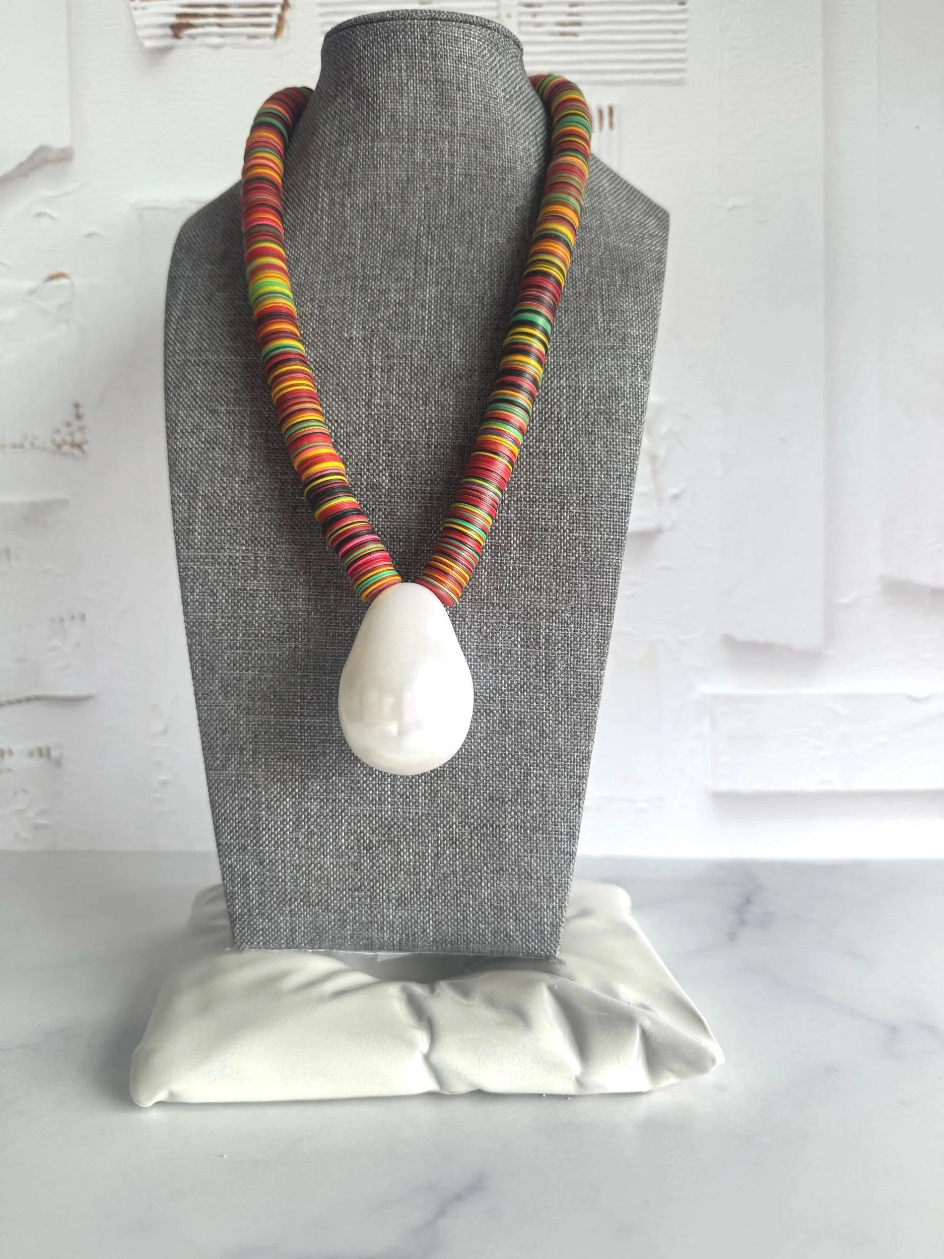 statement necklace with colorful vinyl disc beads and vintage lucite pearl pendant .