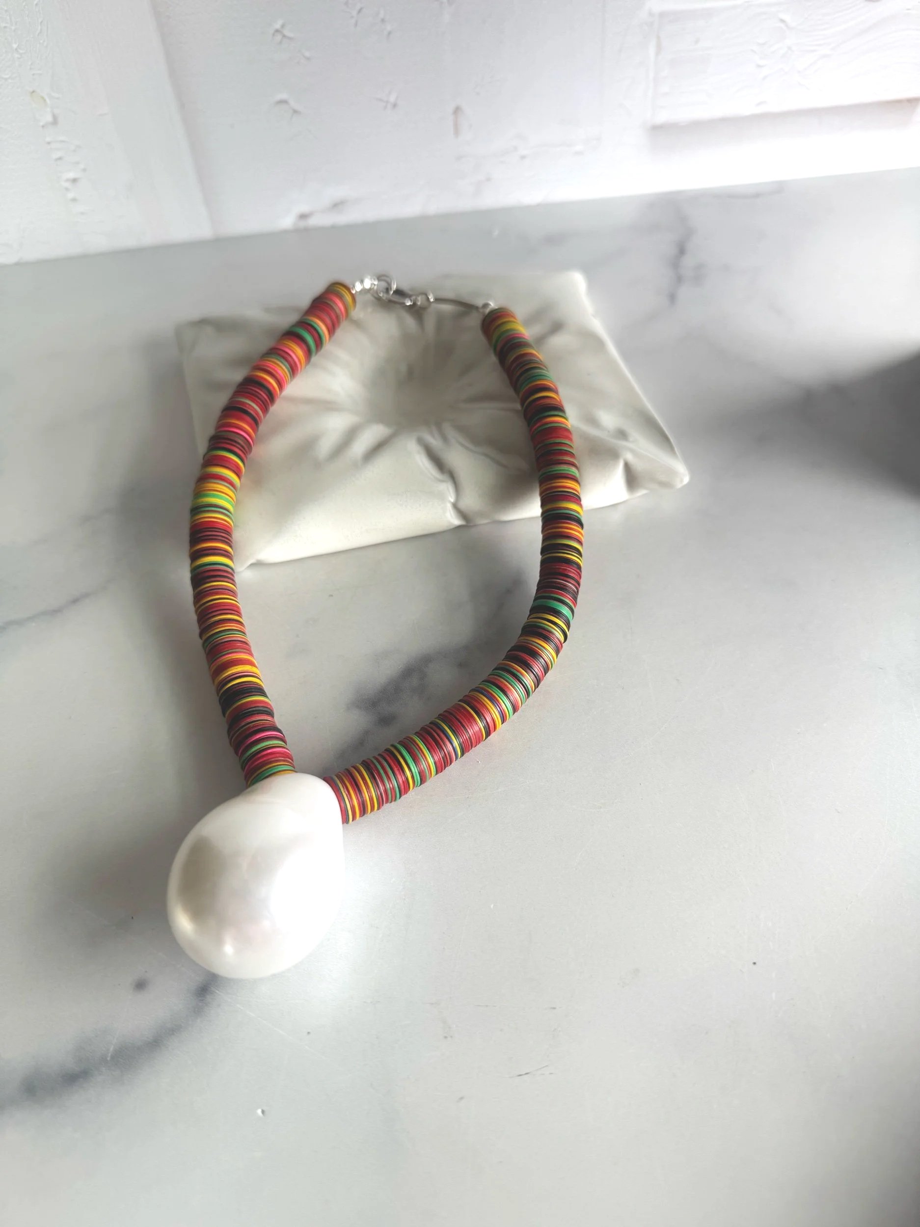 statement necklace with colorful vinyl disc beads and vintage lucite pearl pendant .