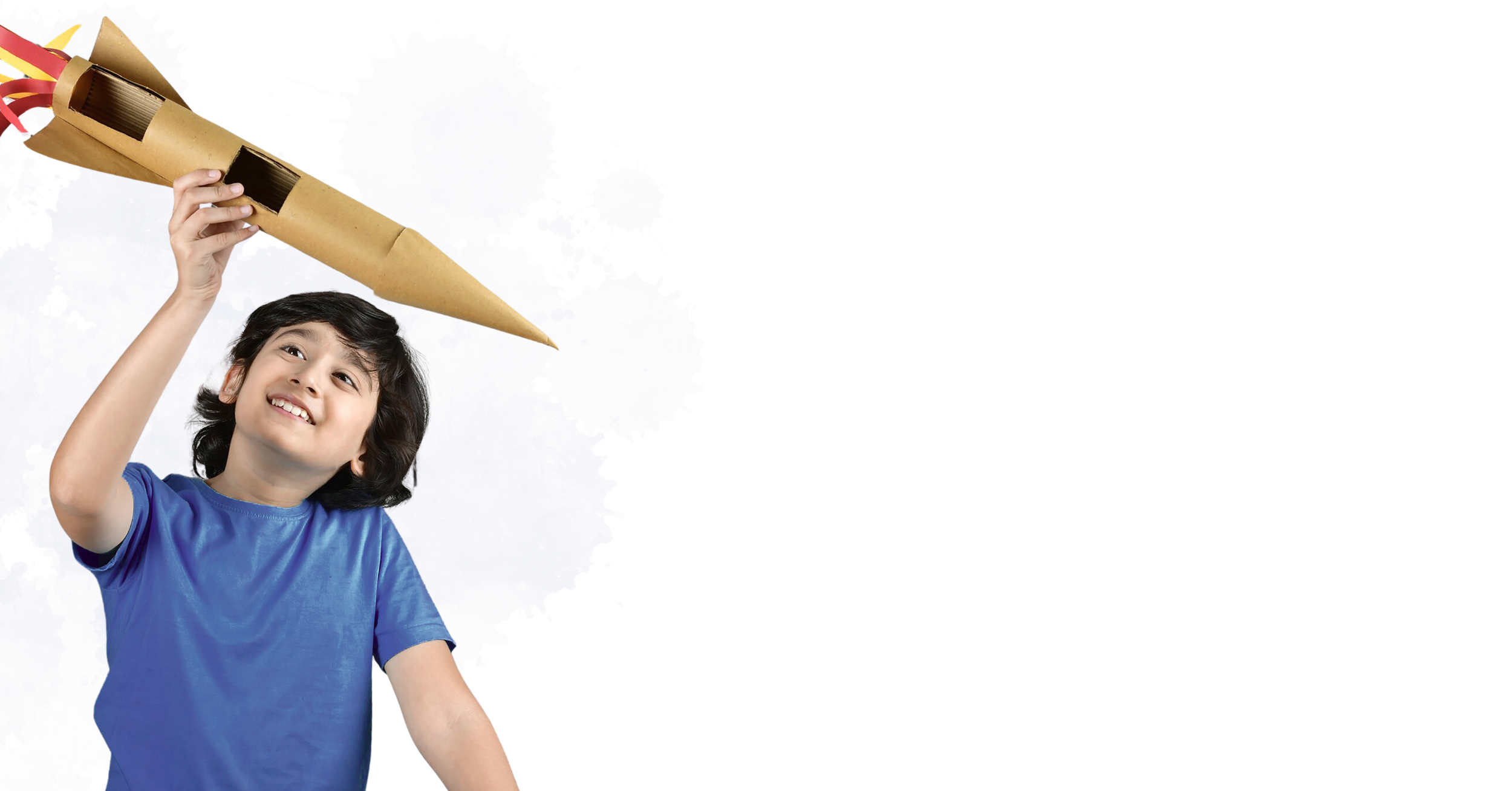 A young child with dark hair wearing a blue shirt holding a large, tube-shaped cardboard party horn with red and yellow ribbons attached.