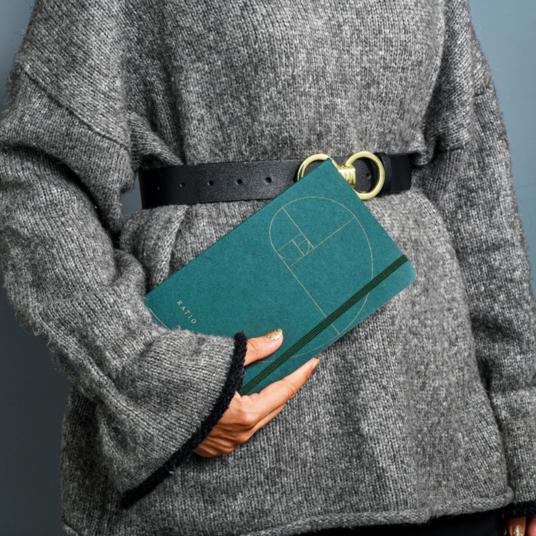 Woman in grey jumper holding a book