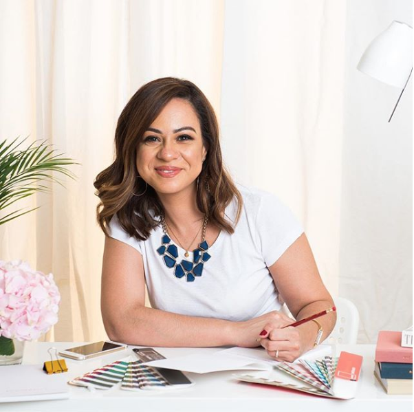 Woman sitting at a table with pencil in hand smiling