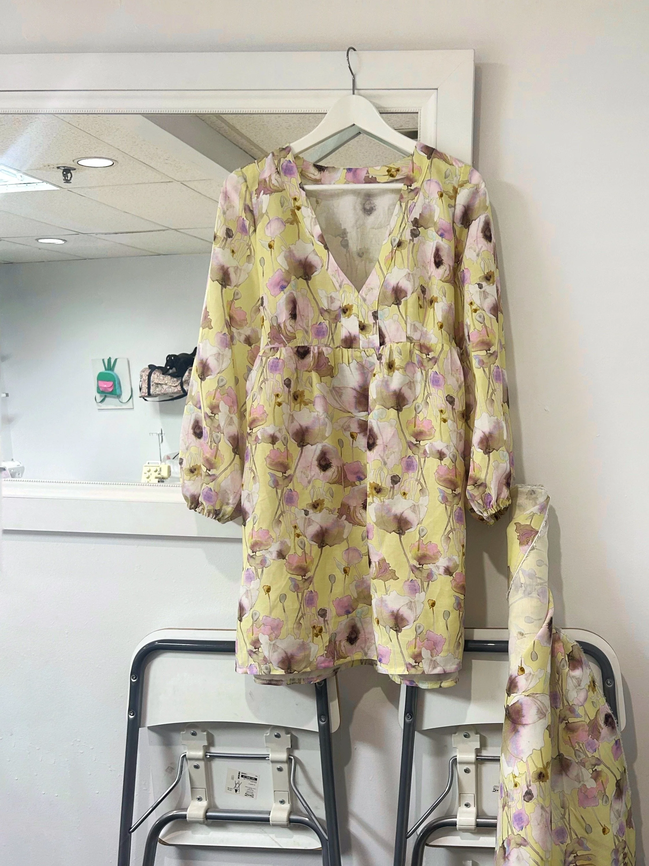Yellow floral dress hanging in a sewing studio