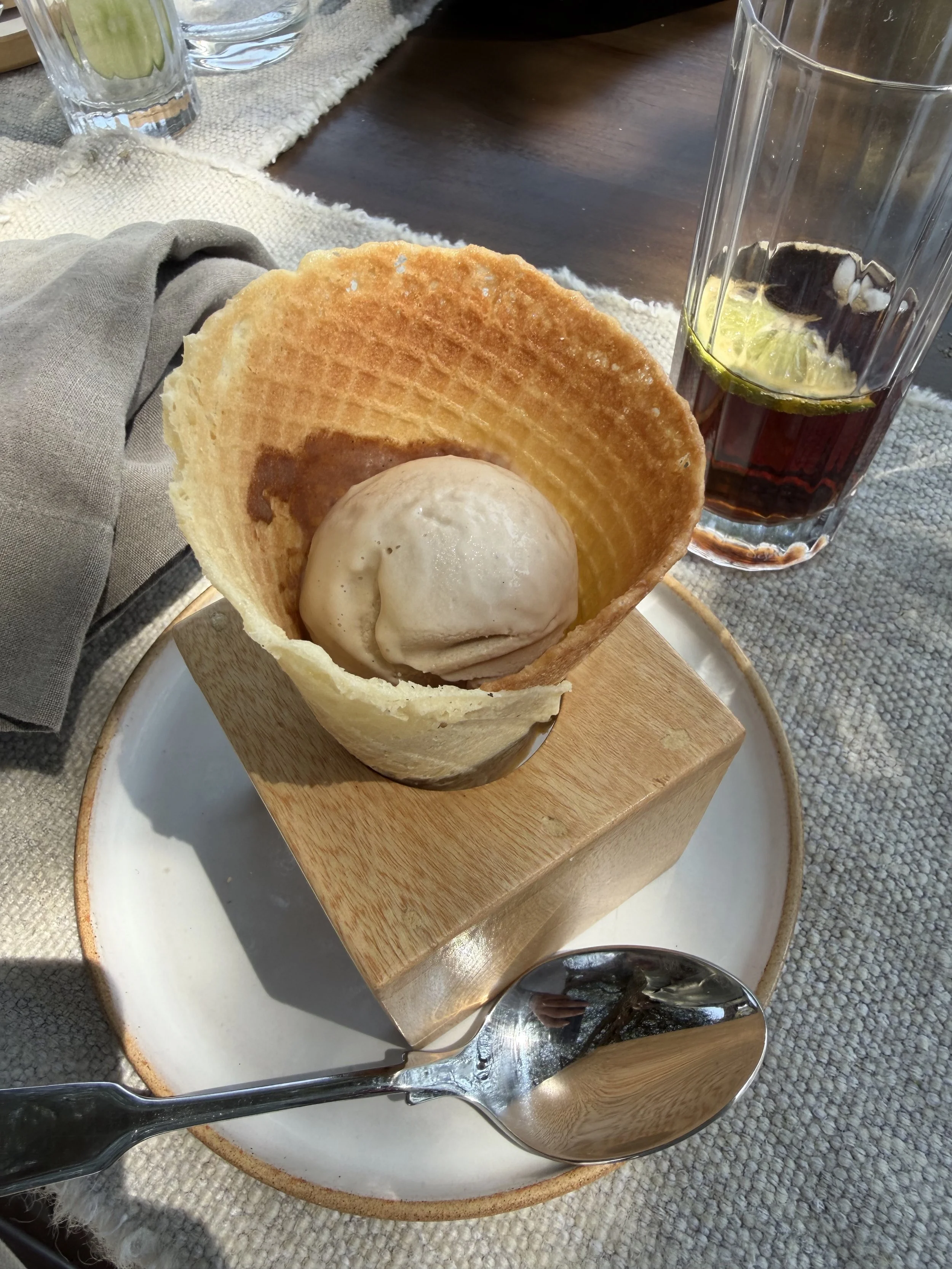 Ice cream served in a wafer cone on a wooden block for dessert at lunch