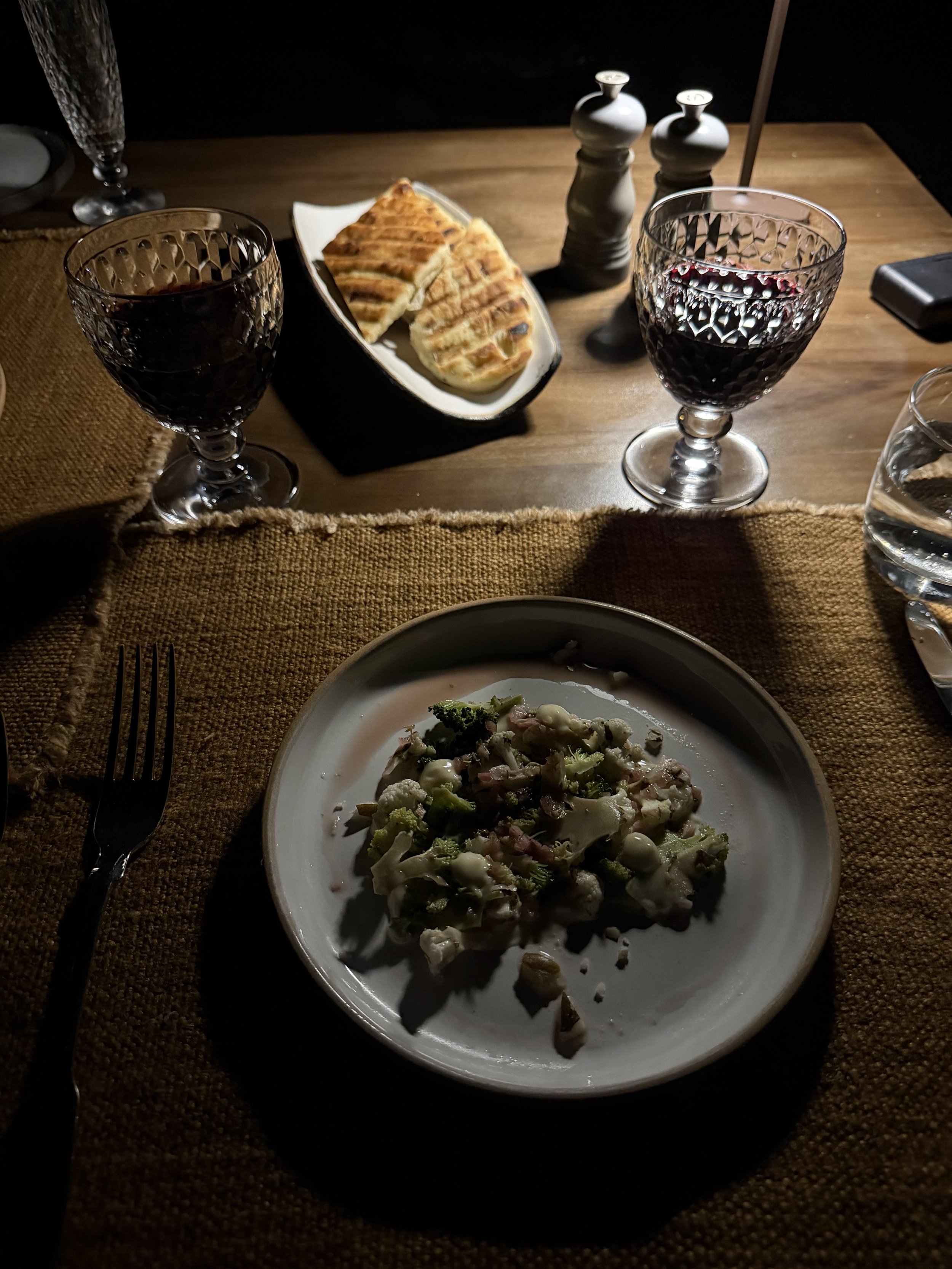 An evening dinner course at Mila, with red wine and grilled flatbread on the table