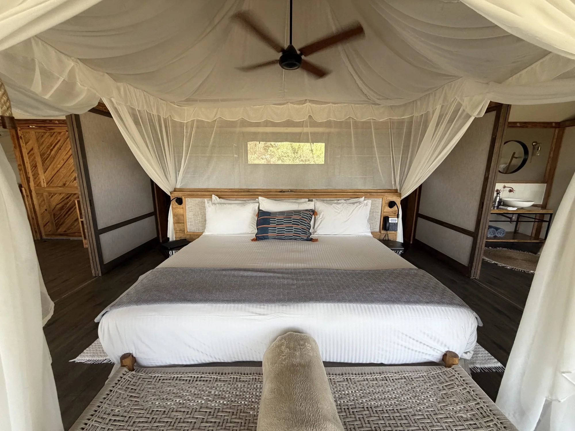 King bed under a mosquito net in a Lemala Nanyukie suite