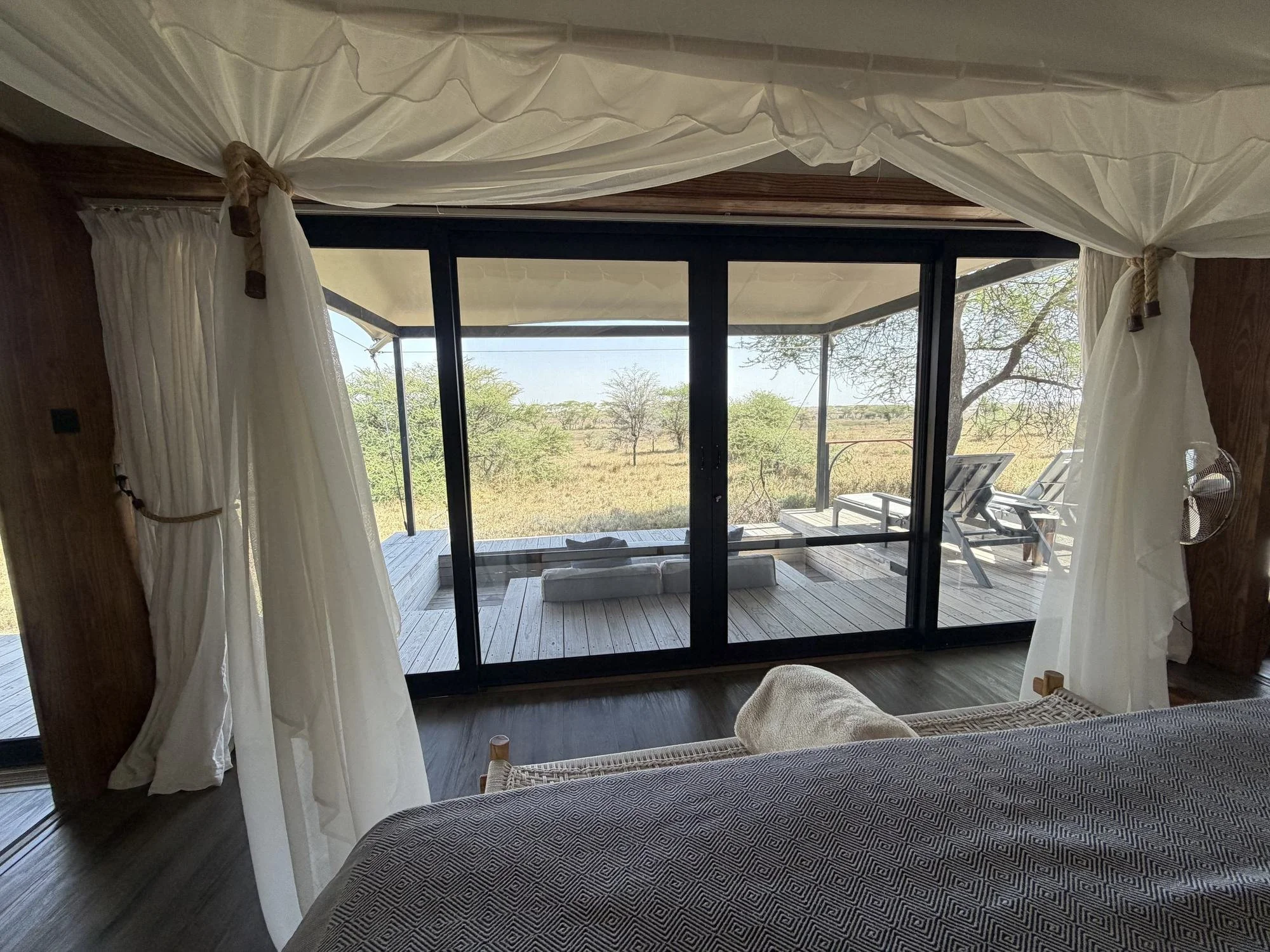 View from the bed through the sliding doors to the private deck at Lemala Nanyukie