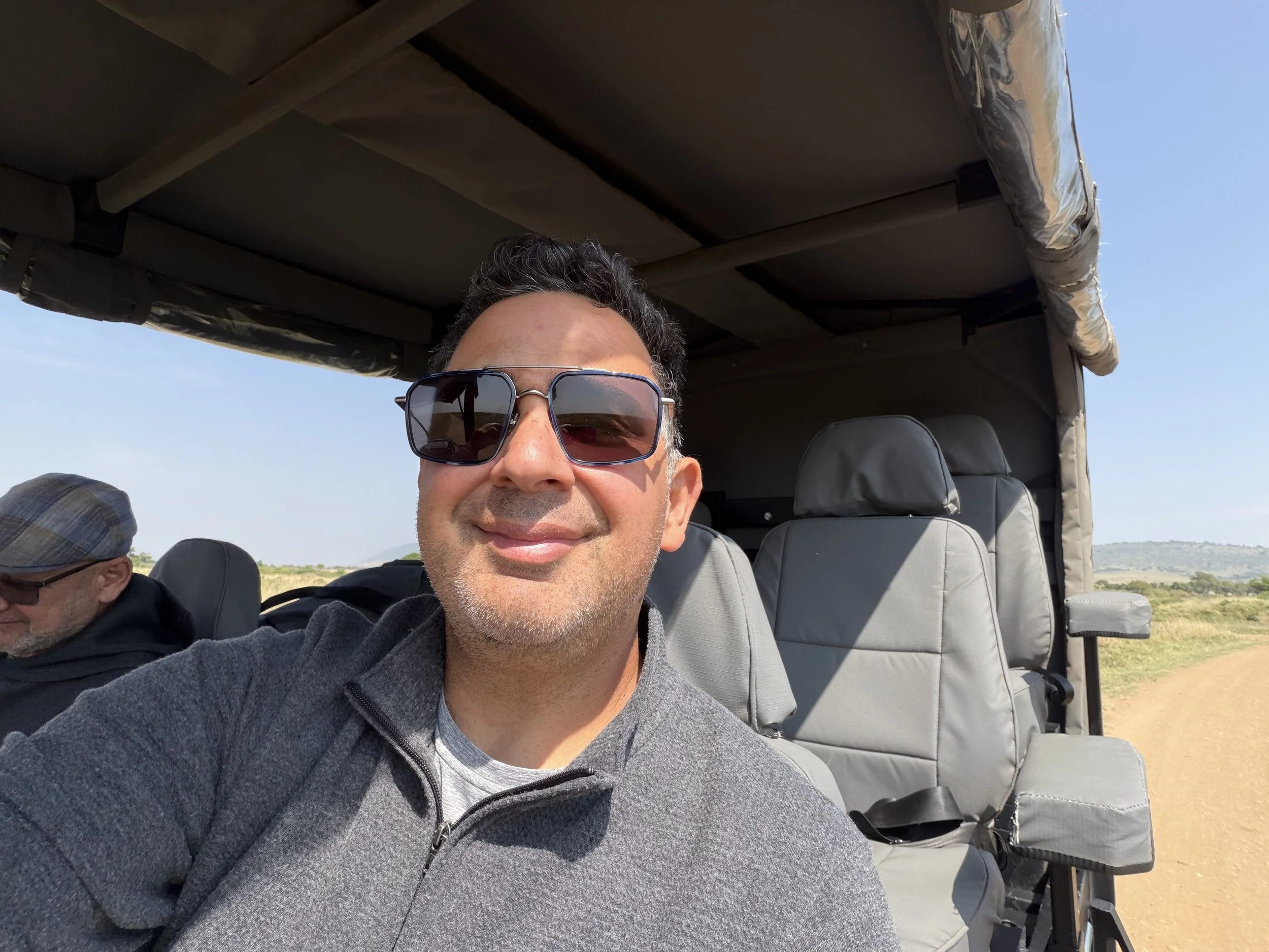 man in safari vehicle smiling
