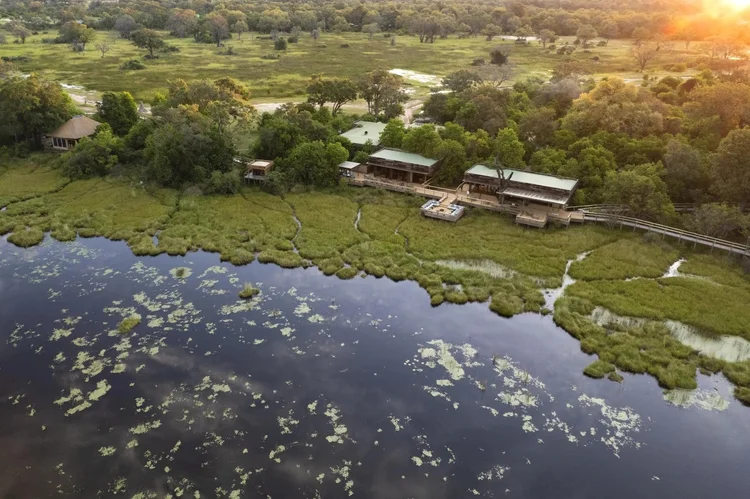 Aerial view of Vumbura Plains above lily-covered water and green marshland in the Okavango Delta, Botswana