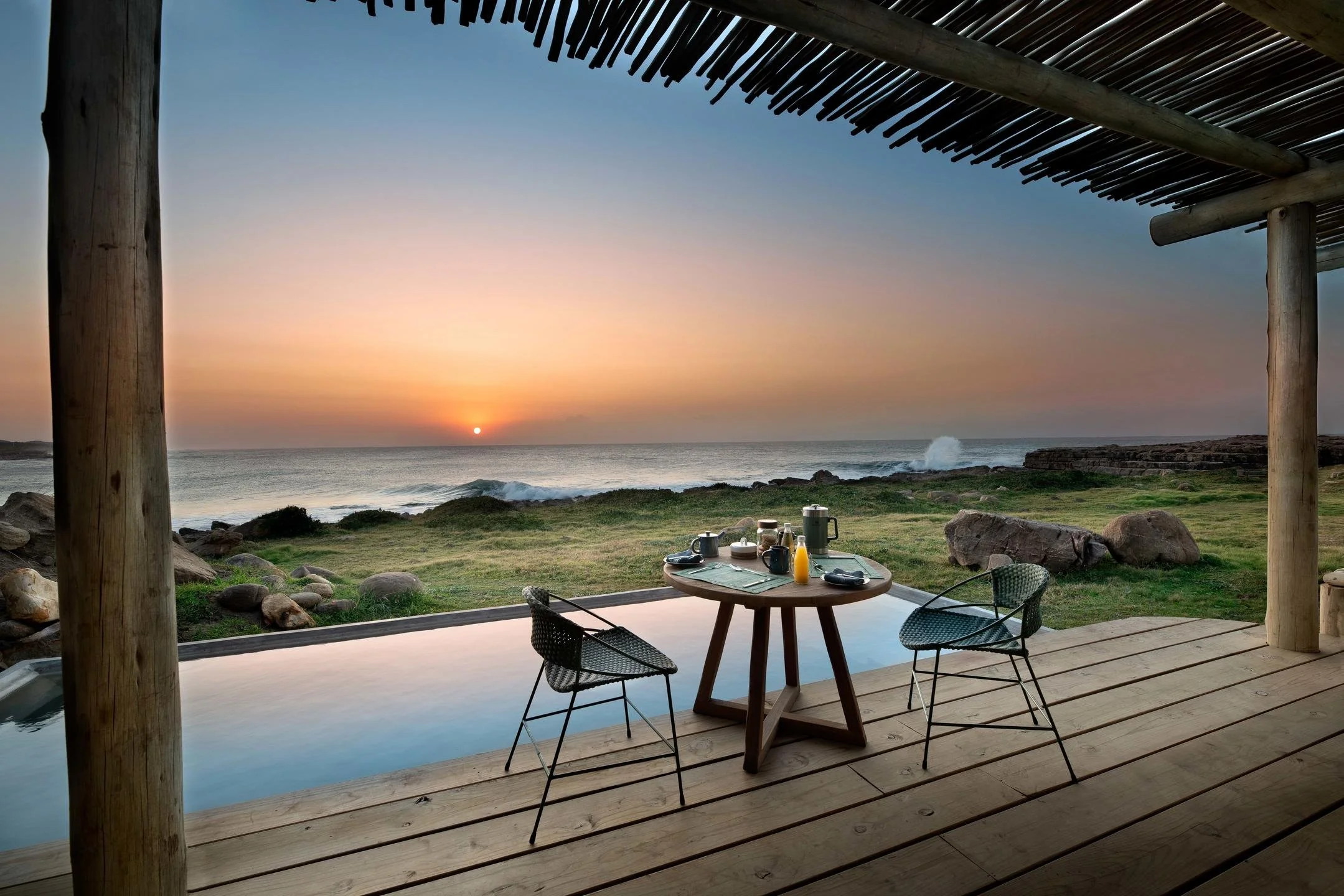 Private deck at GweGwe Beach Lodge with Indian Ocean views at sunset