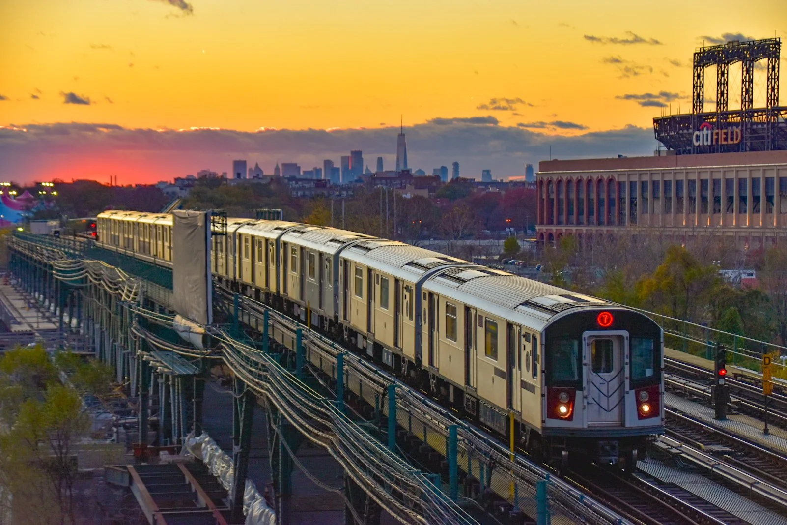 San Francisco Bay Area Rapid Transit (BART) train heading into the city at sunset with the San Francisco skyline, including the Salesforce Tower, in the background.