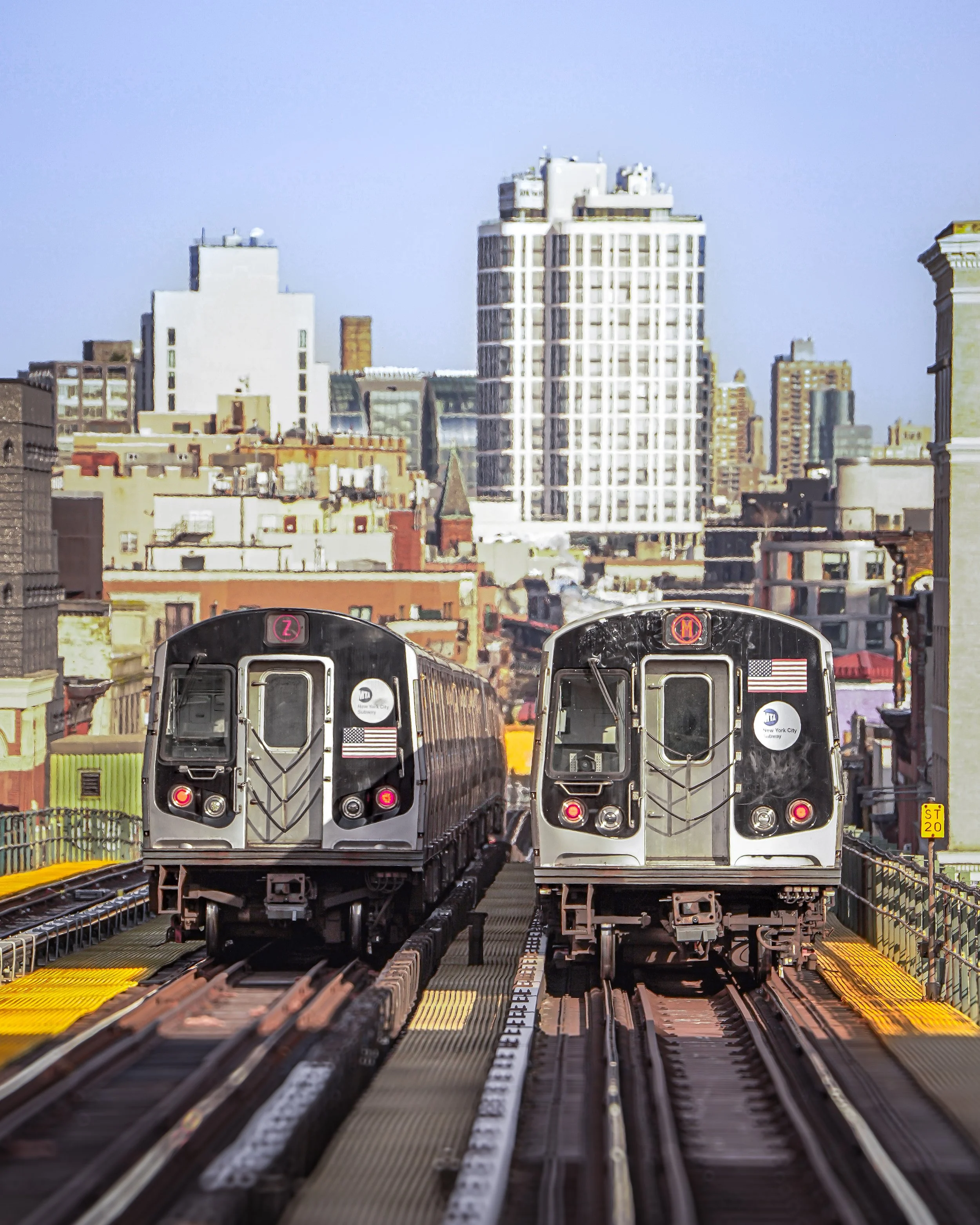 Two subway trains on an elevated track with a city skyline featuring tall buildings in the background under a clear sky.
