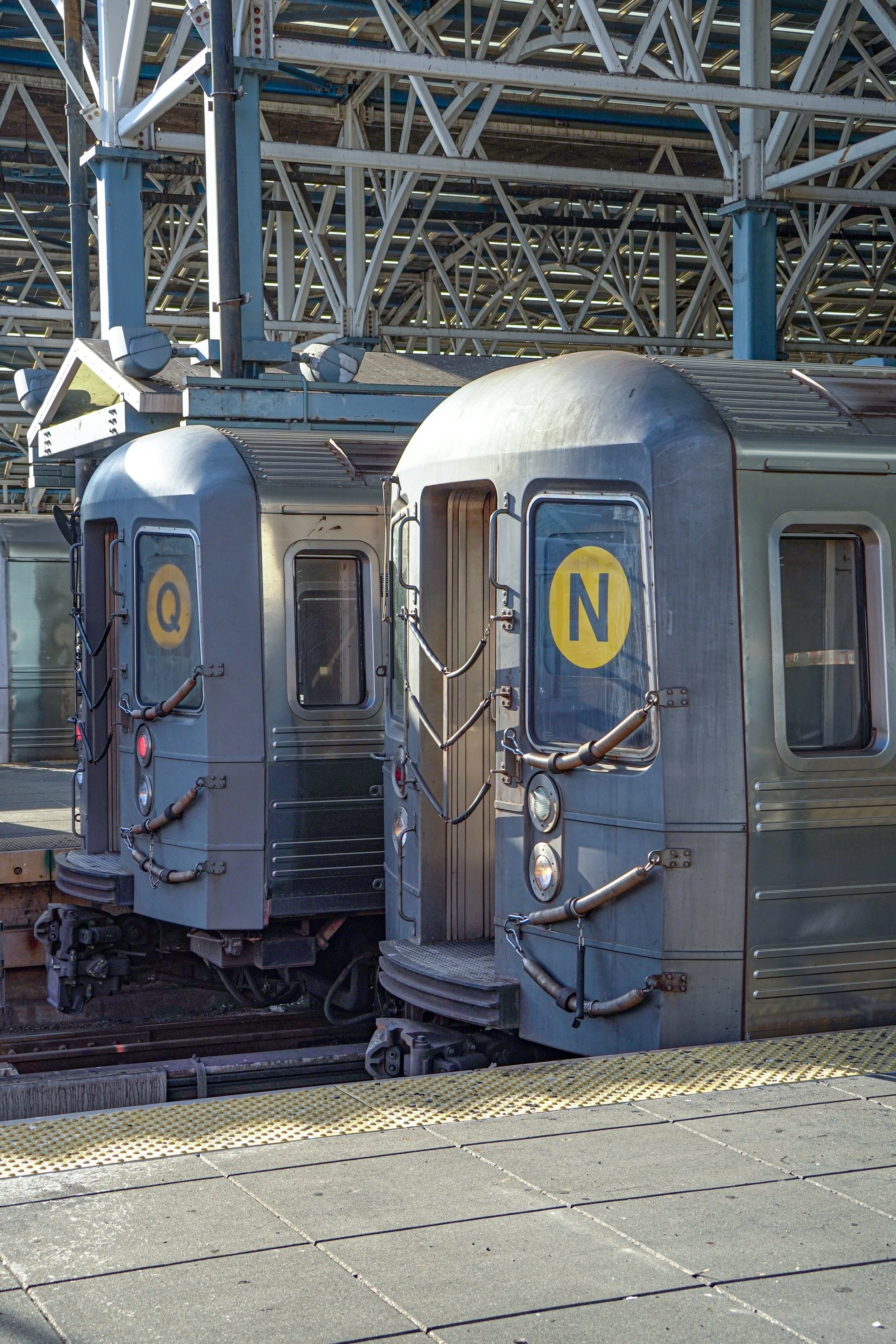 New York City subway train waiting on the platform with the Q and N lines indicated on the front.