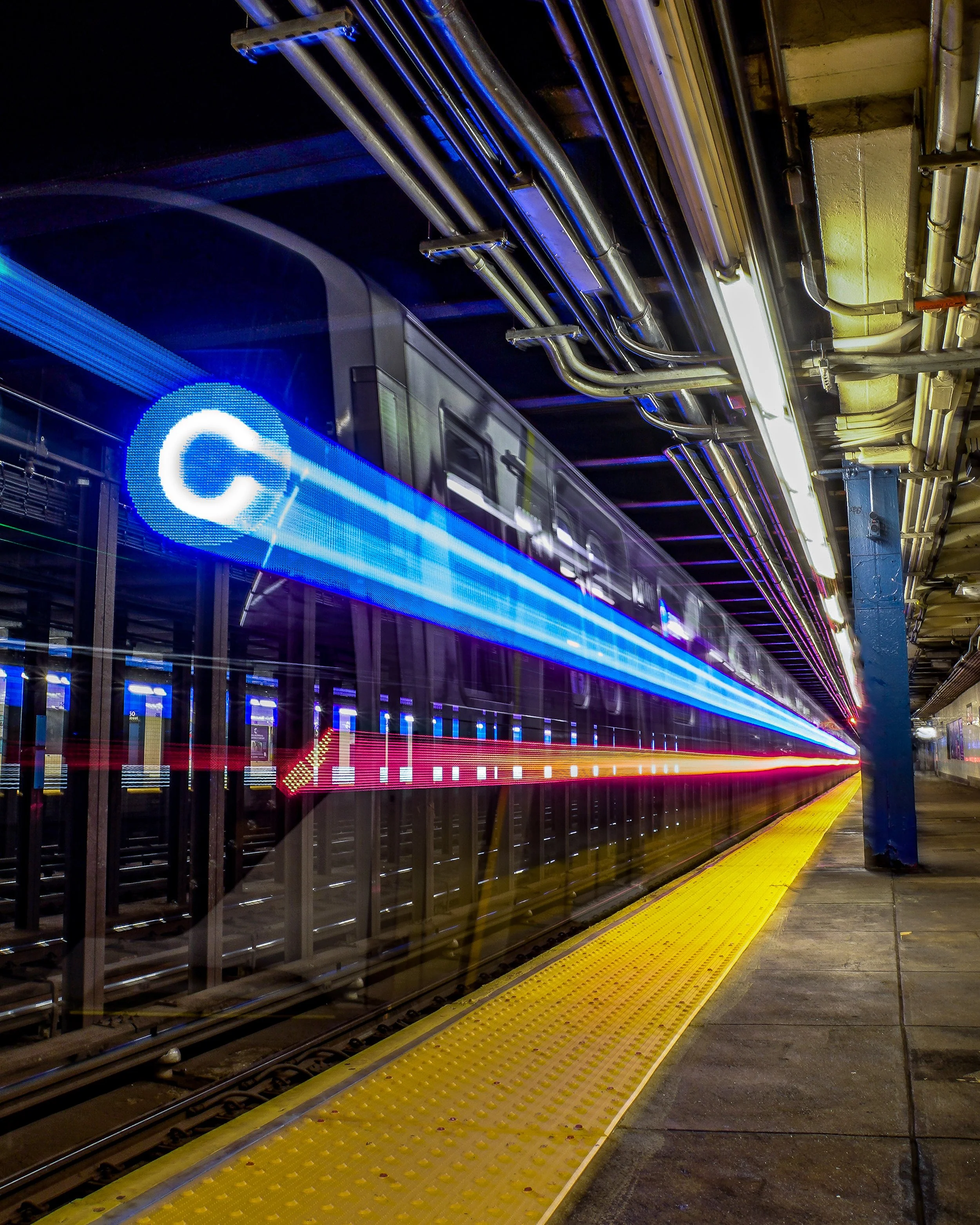 A C train subway long exposure ghost train departing at a station at night with colorful light trails from long exposure photography.