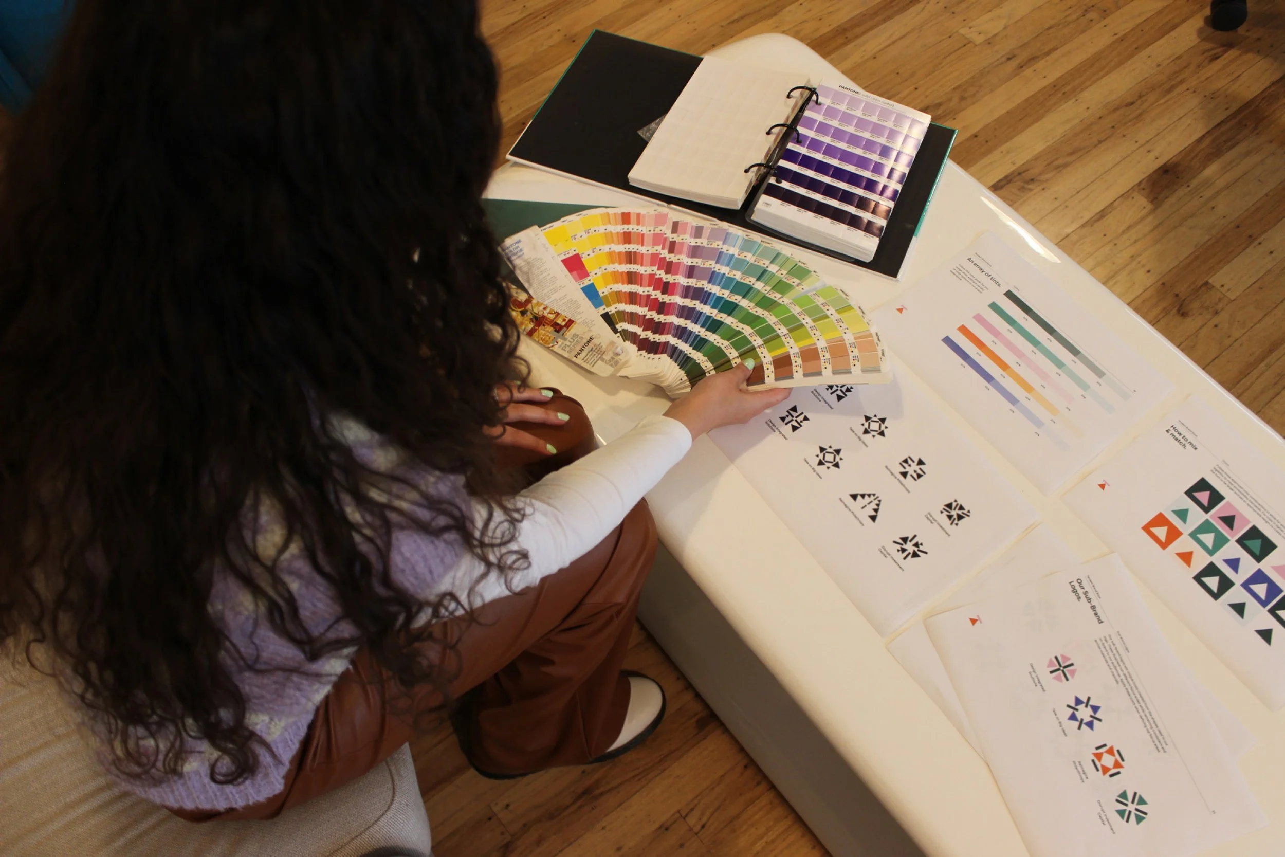 Sierra holding pantone color swatches and looking at icon work