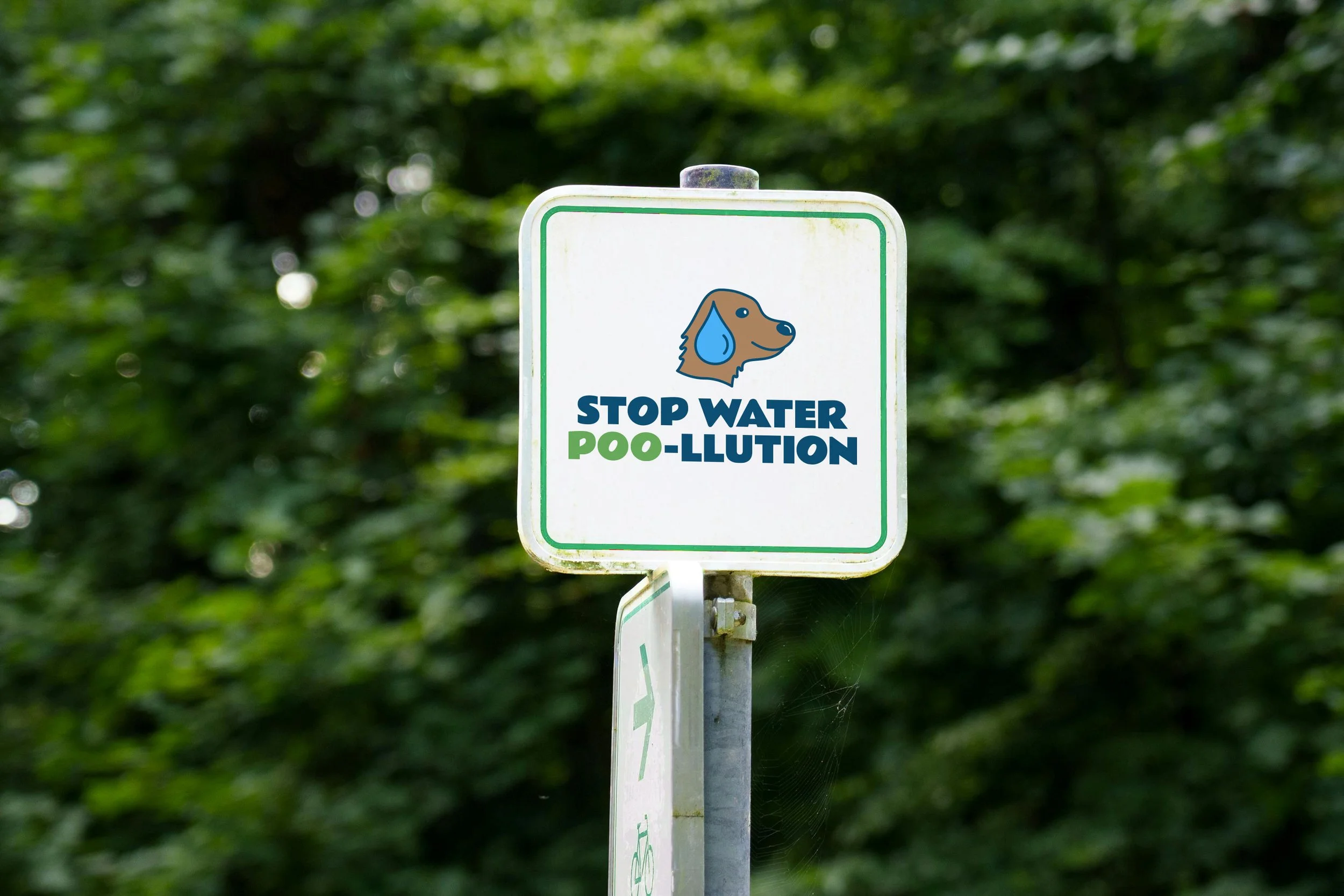 Sign that reads "STOP WATER POO-LLUTION" with illustration of dog with a water droplet as the ear