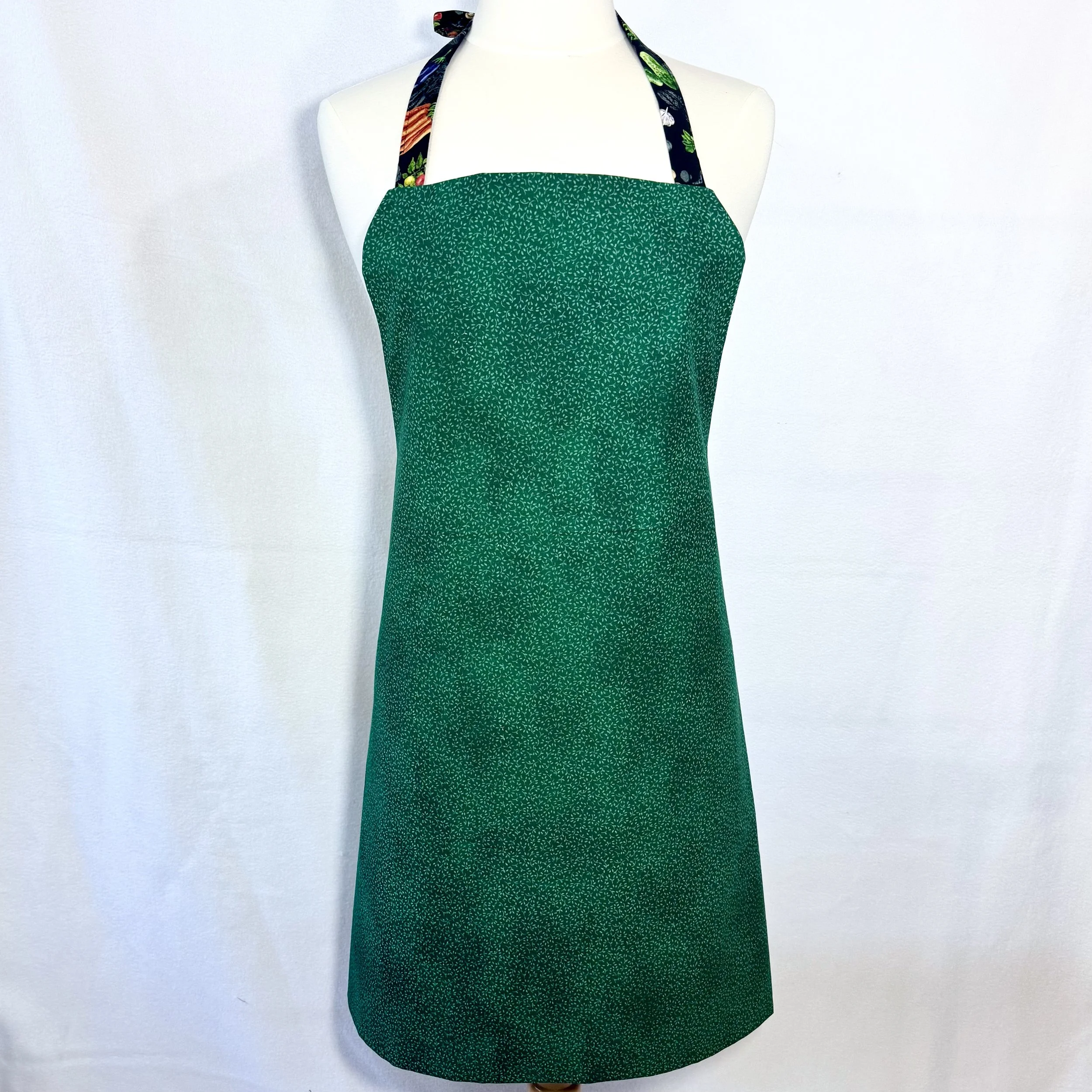 Reverse side of Good Food Good Life apron in vibrant green with mini leaf print displayed on mannequin