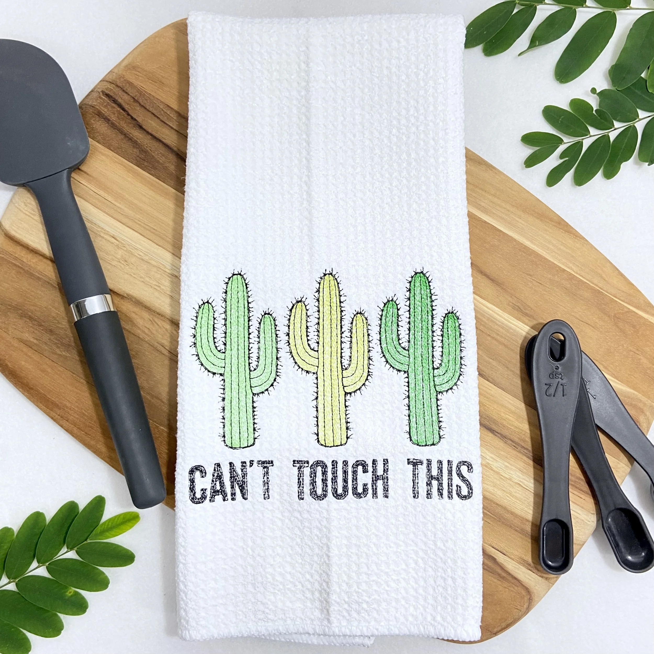 White microfiber kitchen towel with green and yellow embroidered cactus design and “Can’t Touch This” text