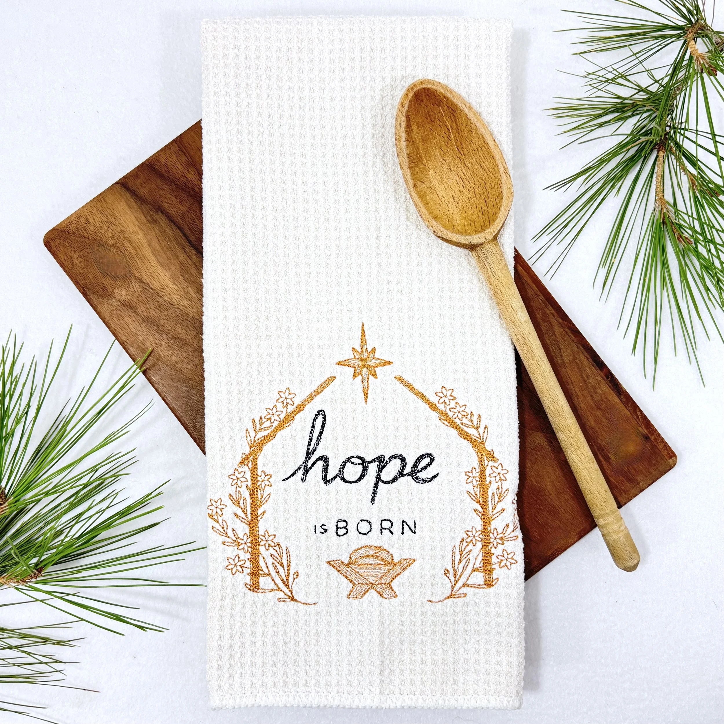 Hope is Born embroidered microfiber kitchen and hand Christmas towel flat lay with greenery and kitchen tools