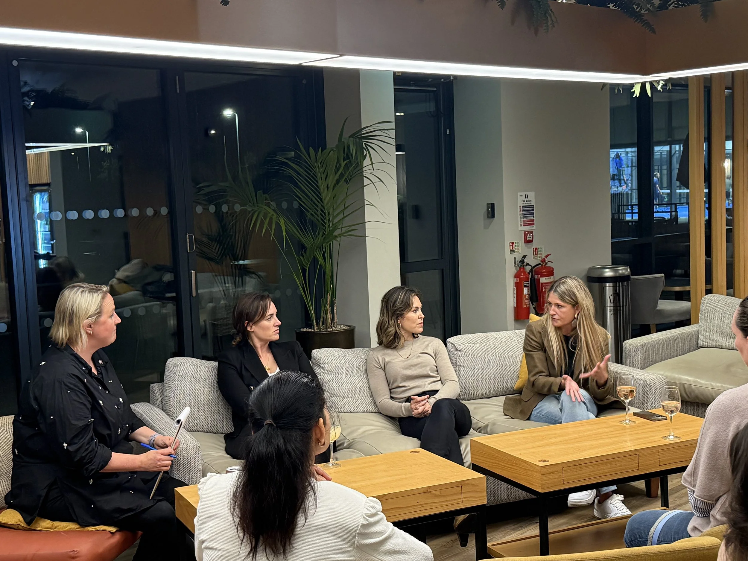 A group of women sat on a sofa discussing their careers