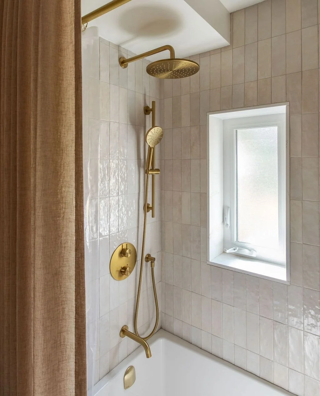 Vertical subway tiles + brushed brass fixtures + dreamy natural light = the most relaxing morning shower setup we can imagine. ⁠
⁠
📸 @salemefayad_photography