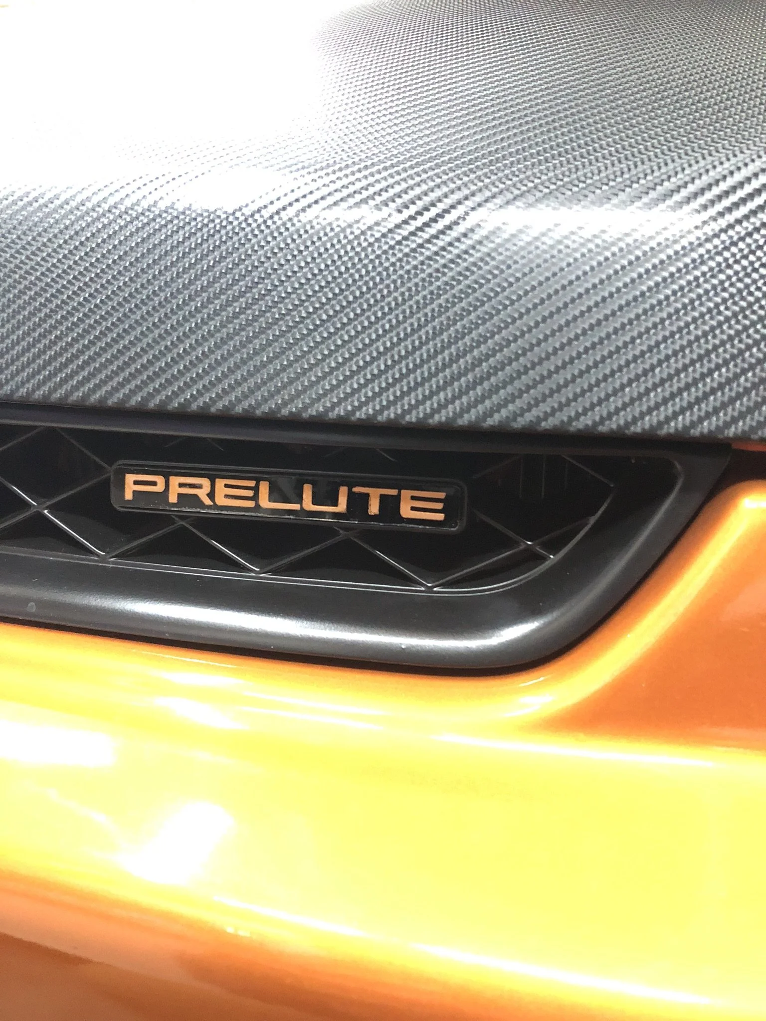 As applied on grille, with orange paint sprayed on inside clear surface.