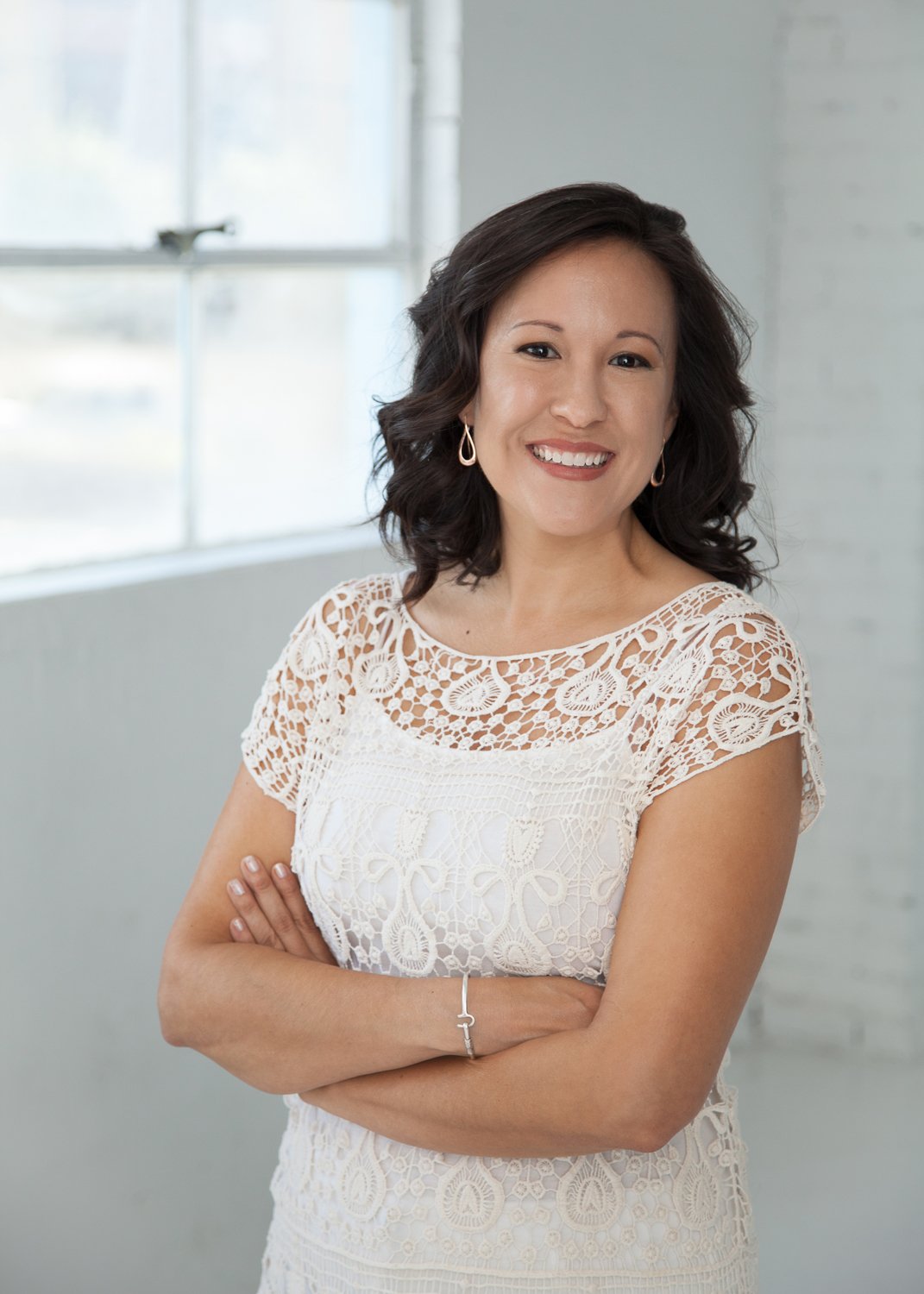 Jenn in white sweater by a window