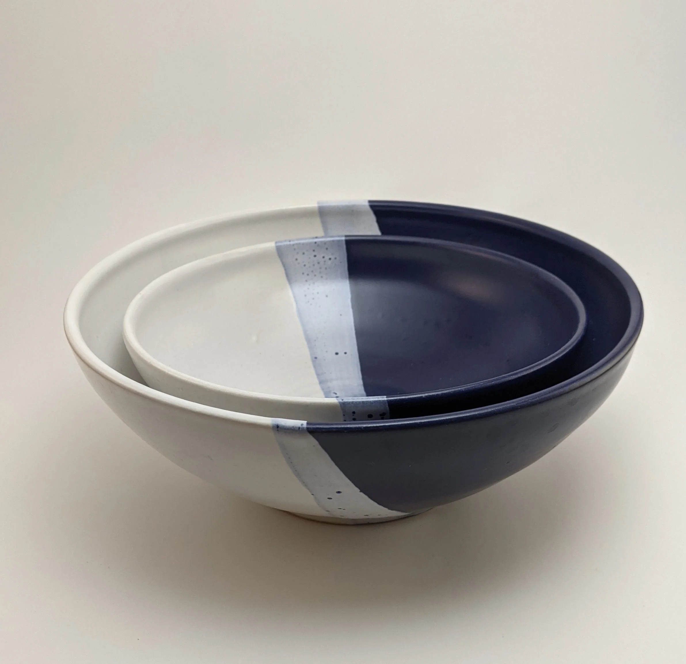 White paper plates stacked with dark blue and white text or graphics, on a white surface.