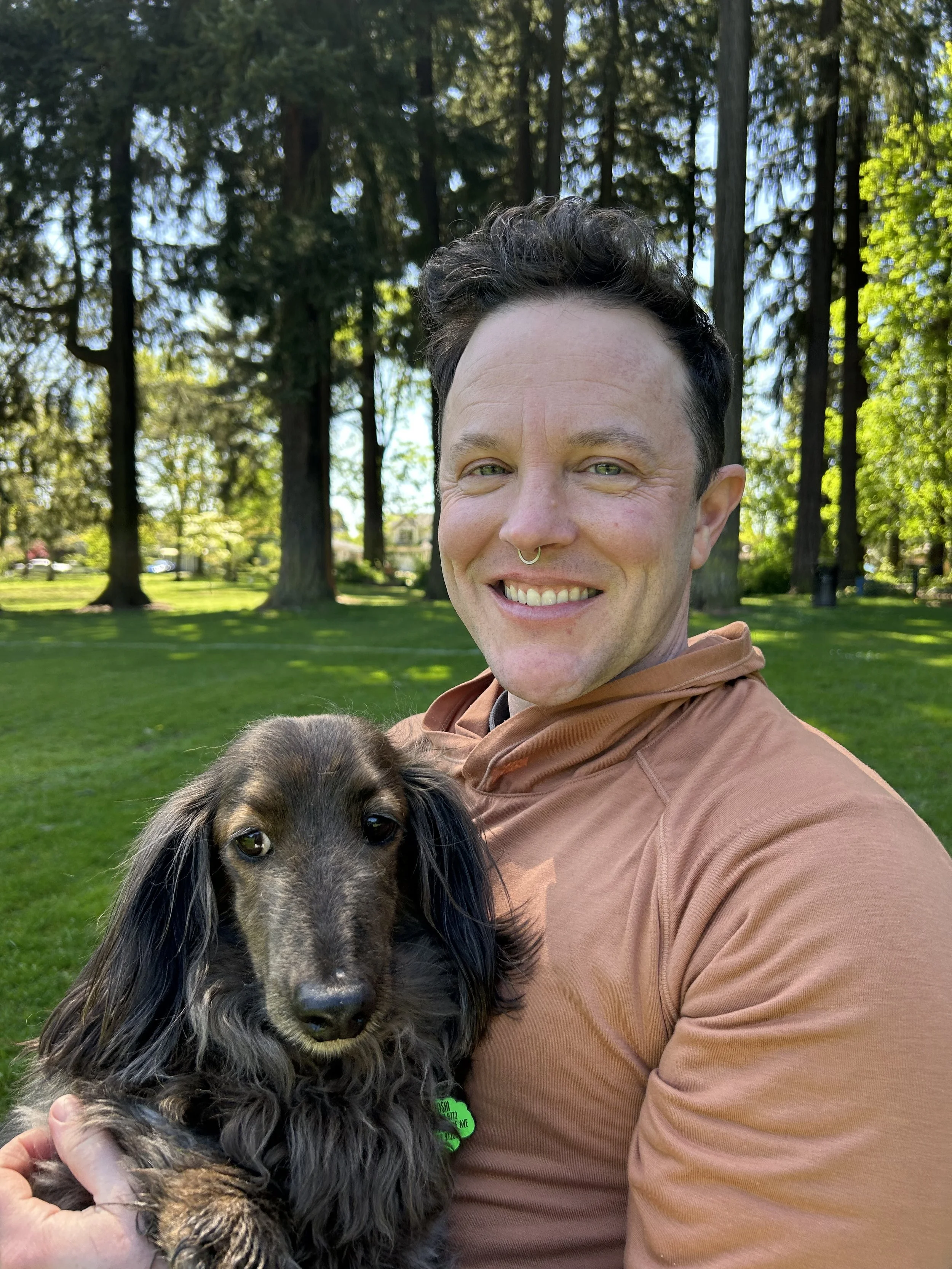 riis ray in a sunny park with their cute dog
