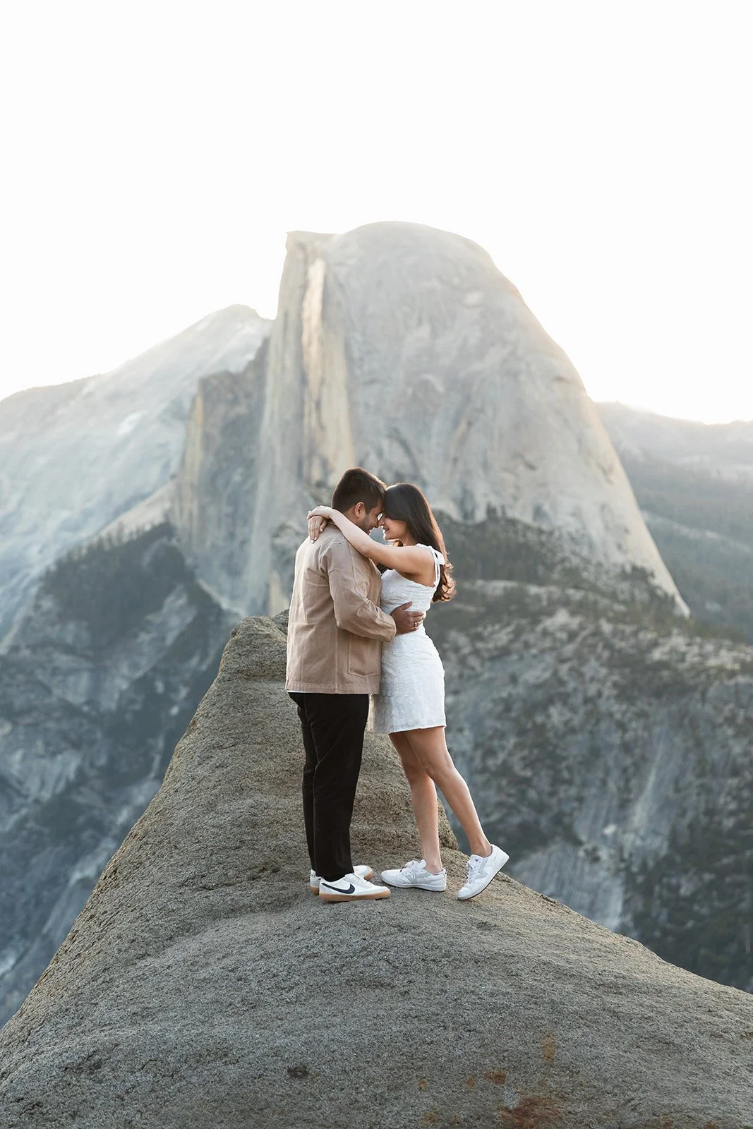 couple embracing at glacier point overlook during sunrise at Yosemite National Park