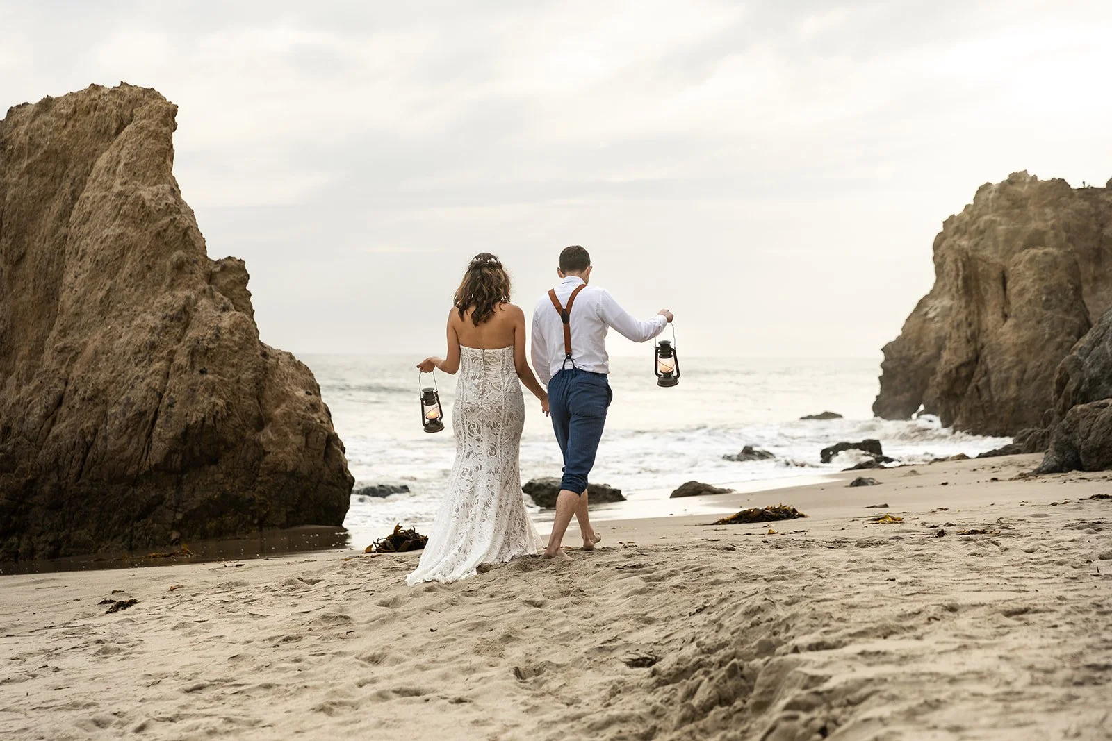 Couple walks along the beach after their toes-in-sand elopement ceremony, they walk away on their own because they prioritize privacy and it's the reason they chose to elope