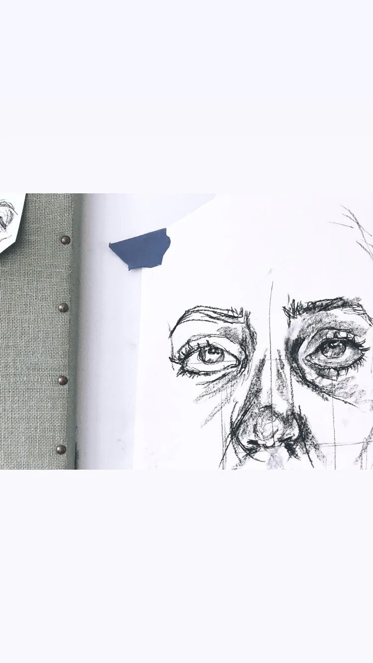 Sketch of a woman's face featuring detailed eyes, eyebrows, nose, and partial forehead on white paper