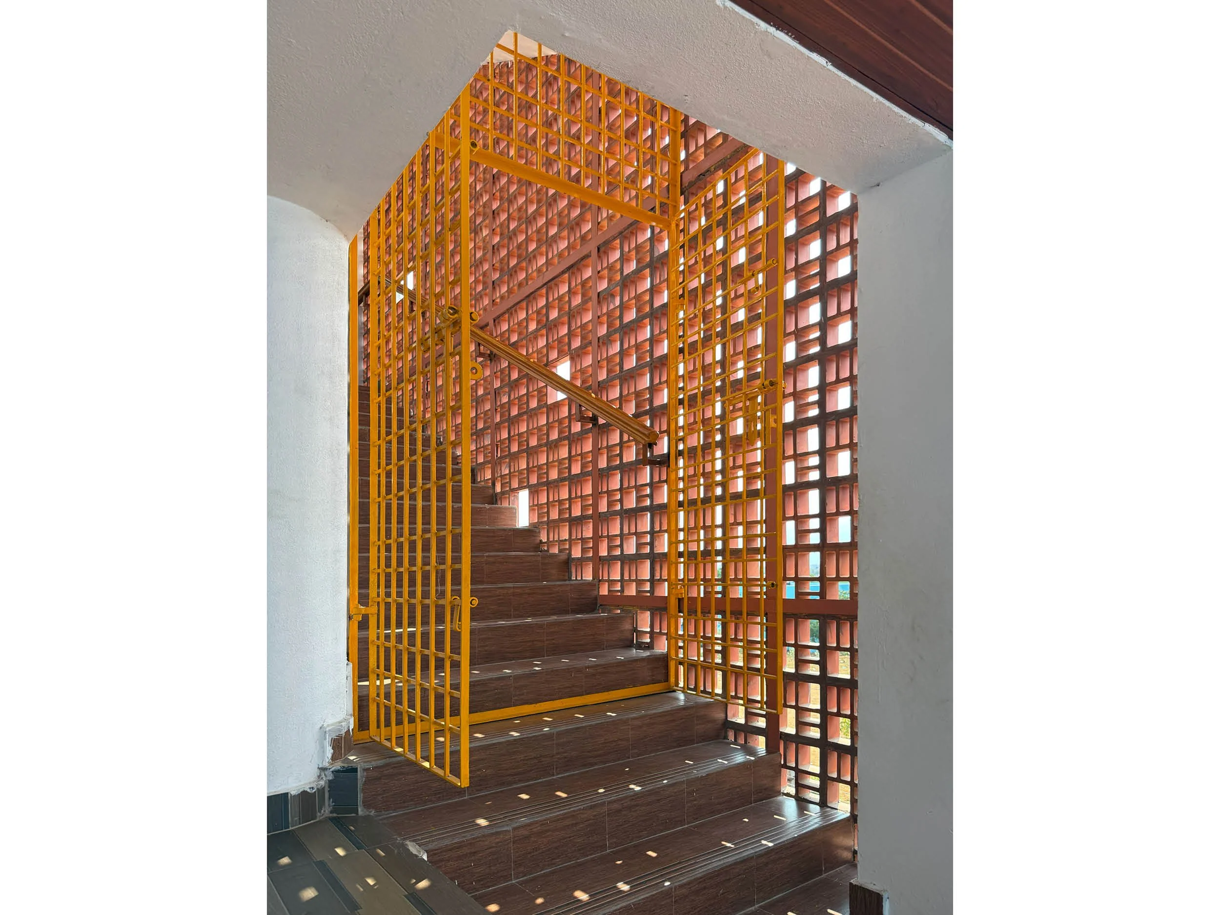Staircase at Bethany Home for Children in southern India showing sunlight streaming through the jali pattern creating shadows on the floor.