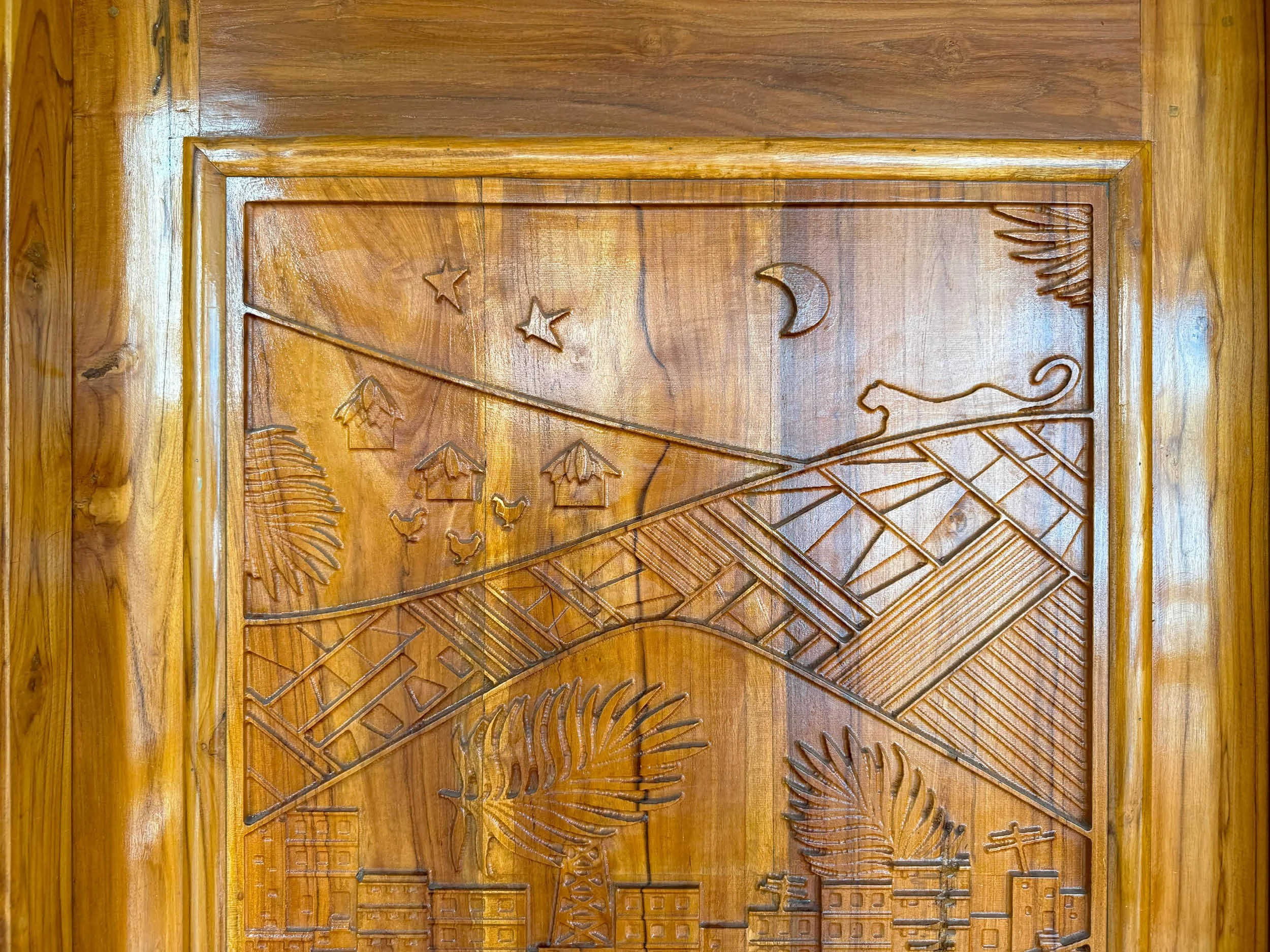 Carved wooden door with celestial symbols, including stars, a crescent moon, and decorative patterns.