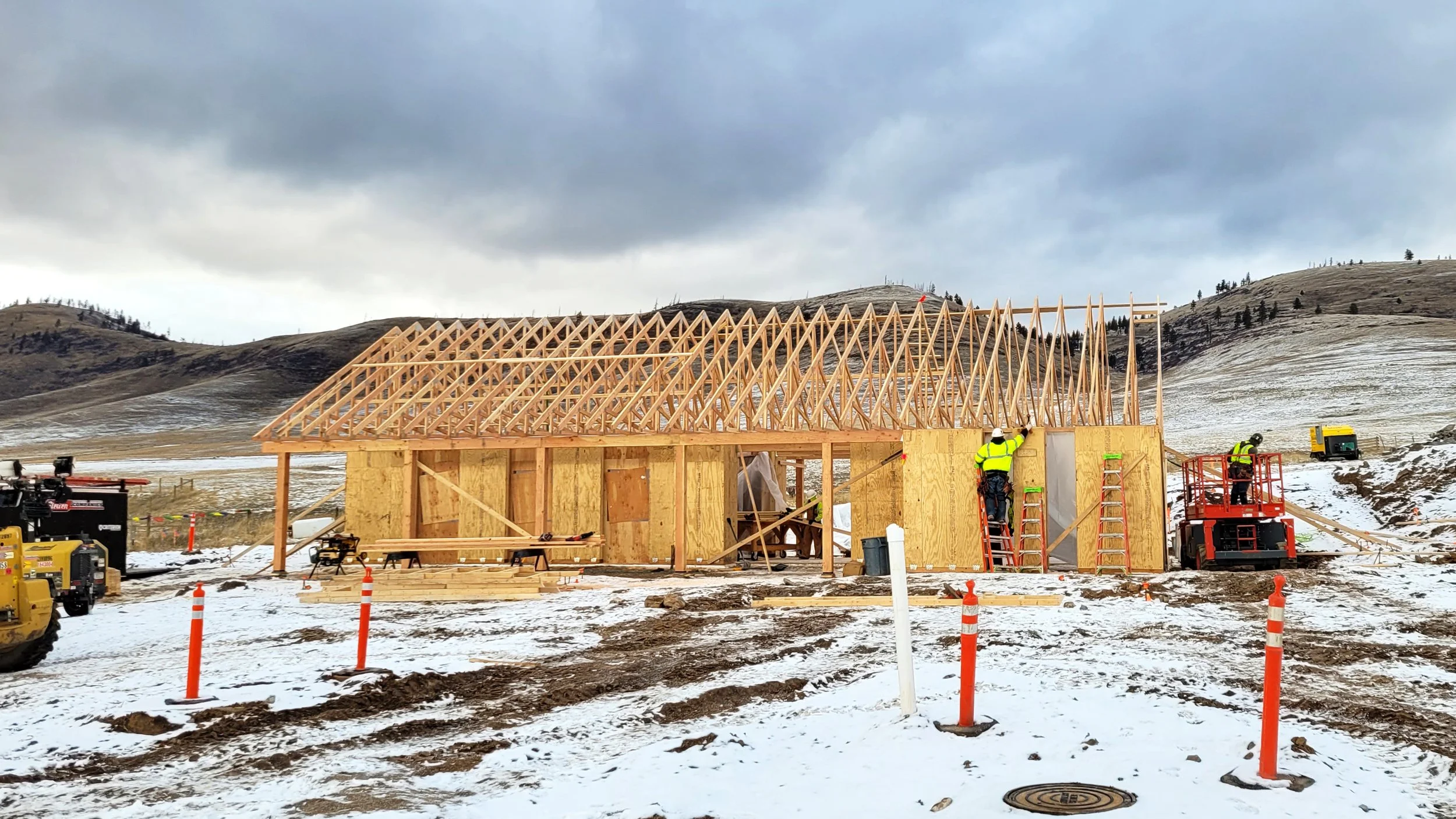 Construction workers assemble from prefabricated parts the Welcome House on a snowy day in Montana.