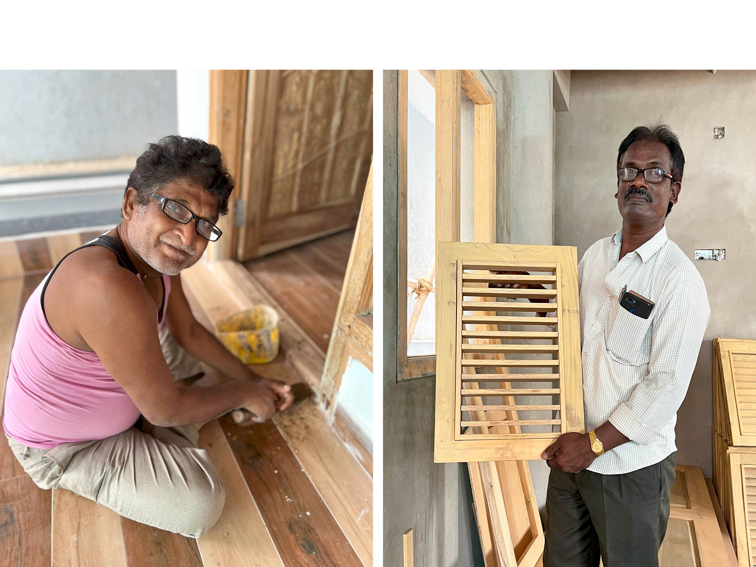 Two men working on furniture construction in a woodworking shop. The man on the left wears a pink tank top and glasses, working on a small item. The man on the right, dressed in a white shirt, holds a wooden furniture frame, with other wood pieces su