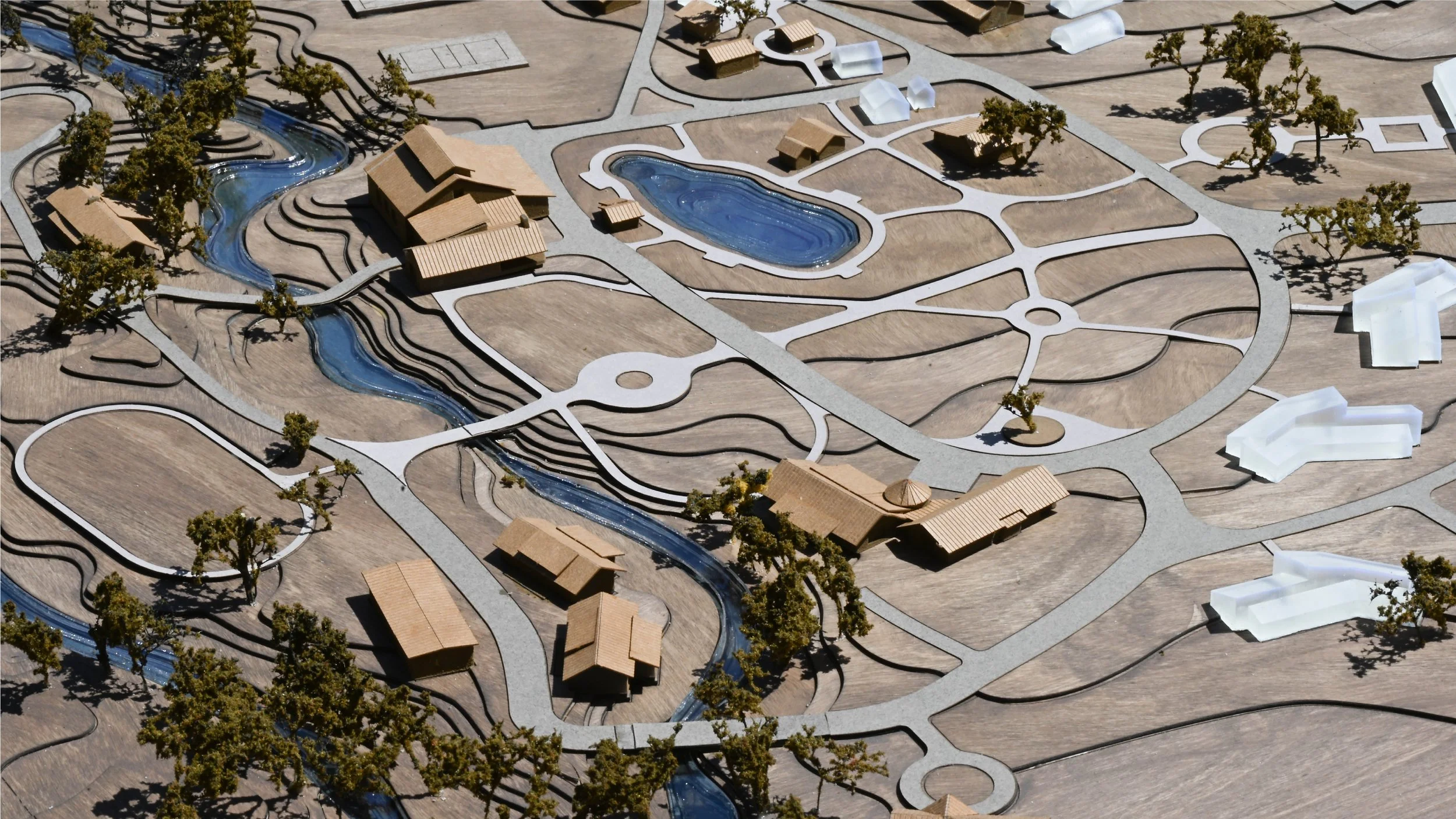 A detailed view of the architectural model of the Lighthouse Ranch featuring winding roads, stream, trees, and buildings.