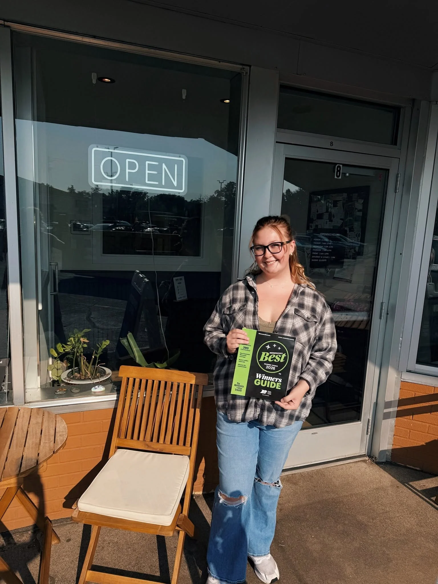 A woman proudly holds the 2026 Star Tribune Minnesota Best magazine featuring Compassion Coffee, recognized as Second Place for Best Coffee and Best Coffeehouse in Anoka, Minnesota. This award highlights Compassion Coffee's handcrafted coffee, welcom