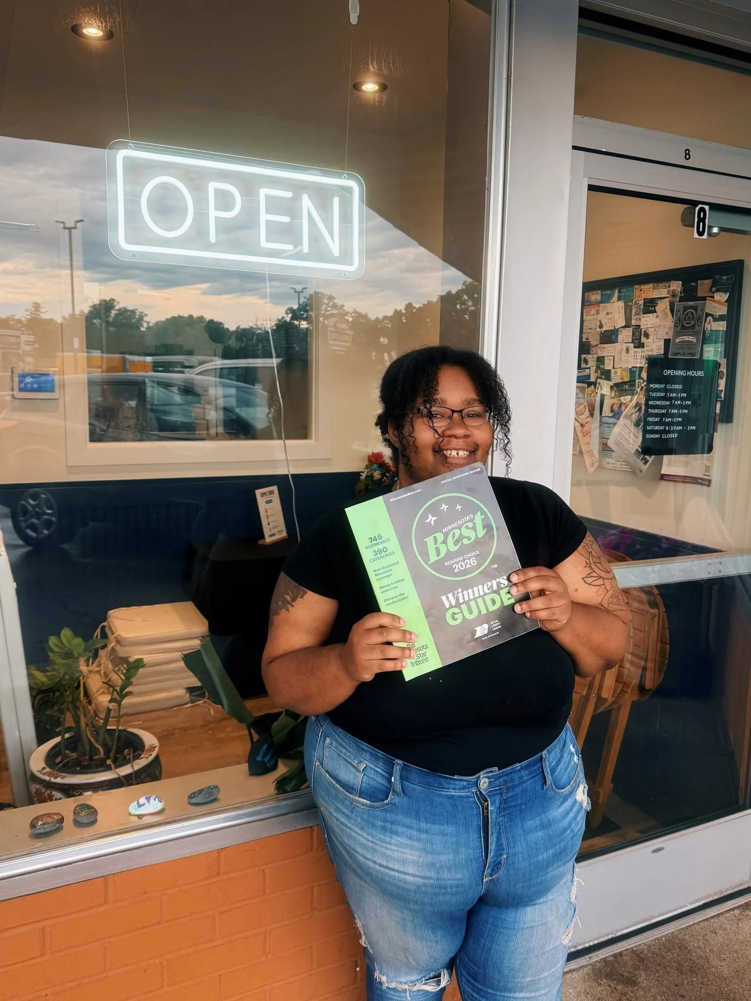 A woman proudly holds the 2026 Star Tribune Minnesota Best magazine featuring Compassion Coffee, recognized as Second Place for Best Coffee and Best Coffeehouse in Anoka, Minnesota. This award highlights Compassion Coffee's handcrafted coffee, welcom