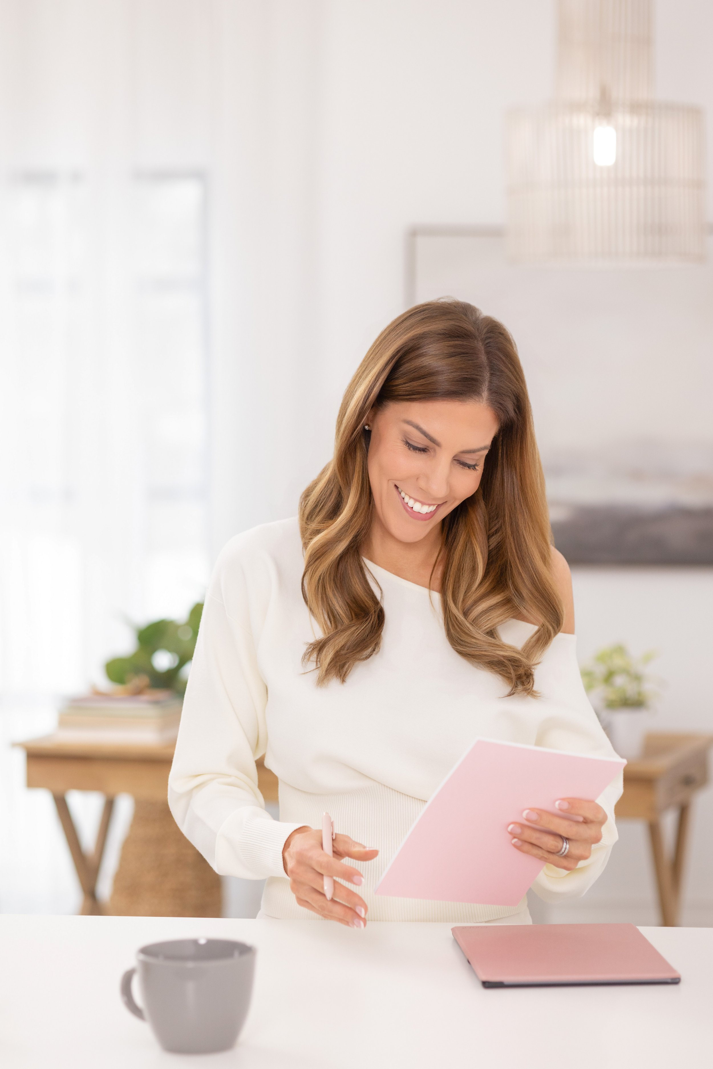 Woman looking down at folder and smiling.  lifestyle headshot by tammy brice in minneapolis